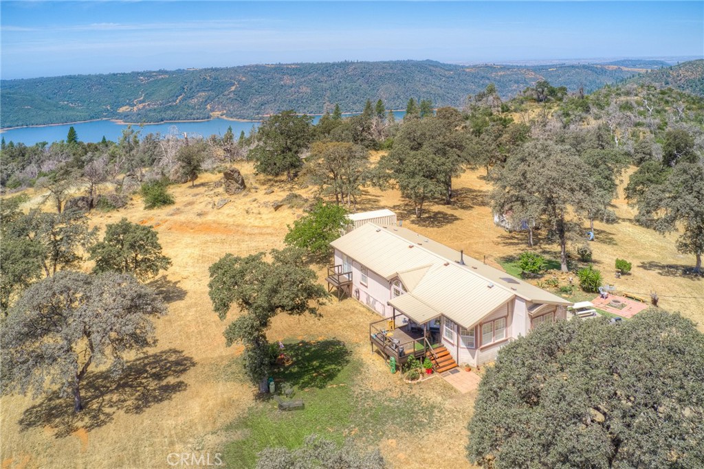 On top of the world, this stunning piece of property is perched above Lake Oroville, providing you with tranquil living on a beautiful piece of property. The seller maintains a large fire break clearance, opening up the property around the home, giving you plenty of outdoor space to garden, recreation, and enjoyment. The manufactured home is spacious, with two nice sized bedrooms, a third room that is currently a family room, large living room, separated dining room, and an large open kitchen with laundry room attached. The house has a metal roof, evaporative cooling and central heating and a pellet stove. There is a great front deck attached for enjoy the days and evenings. As you walk the property you will see the old growth oak trees and massive rock outcroppings. Several level areas and plenty of room to build a shop, gardens, and recreation areas. This home is sitting on over 8 1/2 acres, providing you a perfect spot to surrender to nature and enjoy nature's beauty. Own this home and property today! All information in this listing was pulled from public resources, buyer advised to investigate to satisfaction. Call your Realtor for a private showing!