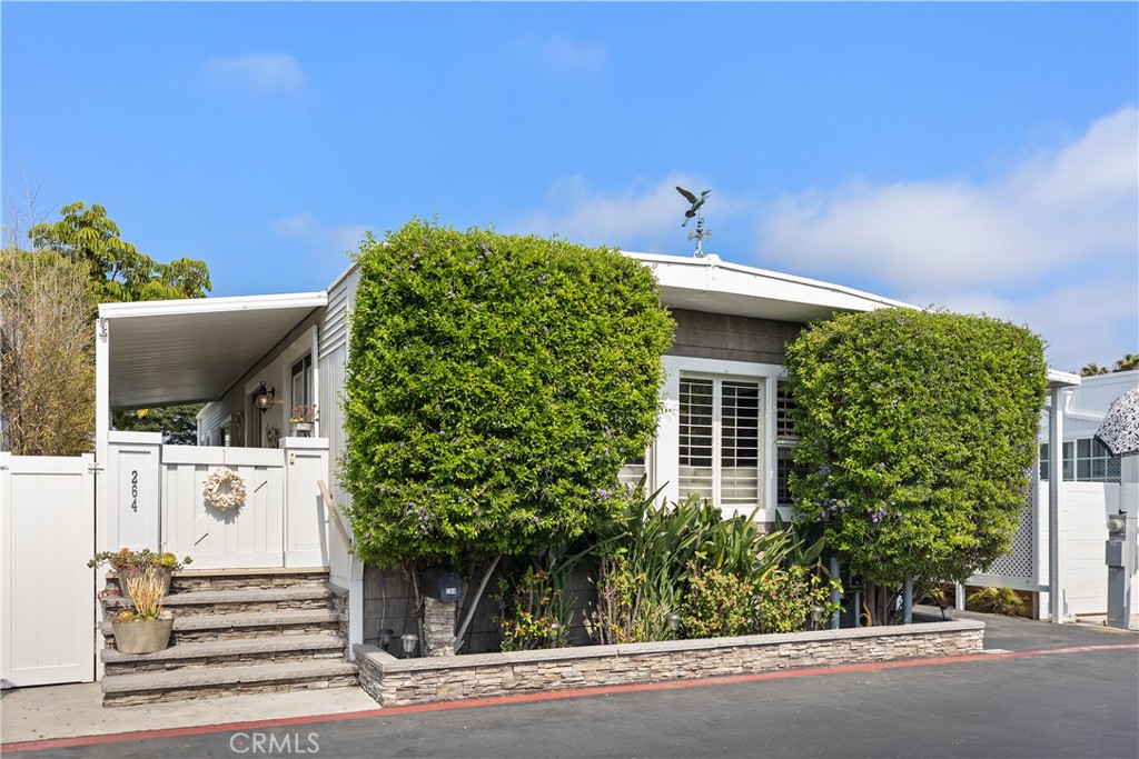 Discover coastal elegance at 264 Mayflower Drive, an inviting sanctuary tucked within Newport Beach’s coveted Bayside Village. This thoughtfully designed two-bedroom, two-bath residence blends comfort and sophistication, offering 960 square feet that lives like 1,200 thanks to its airy, open-concept floor plan. Sunlight fills the living and dining areas, while the kitchen showcases newer stainless steel appliances, generous counter space and a seamless connection for effortless entertaining. Retreat to your serene, private porch and patio, beautifully framed by lush greenery—a tranquil escape ideal for morning coffee, afternoon reading or evening gatherings under the coastal breeze. This home has been updated with central A/C and heat, a separate inside laundry room, covered carport and ample storage which adds both practicality and ease. Here, you’re not just purchasing a home—you’re stepping into an exclusive Newport Beach lifestyle and let's not forget, there are NO HOA dues or land taxes. Community perks include a private beach, kayak launch, scenic bike trails, two pools, spas, BBQs, fire pits, dog park and two clubhouses—plus year-round events. All this just moments from Newport Dunes, Back Bay and the marina! Every day feels like a vacation in one of Orange County’s most sought-after enclaves.