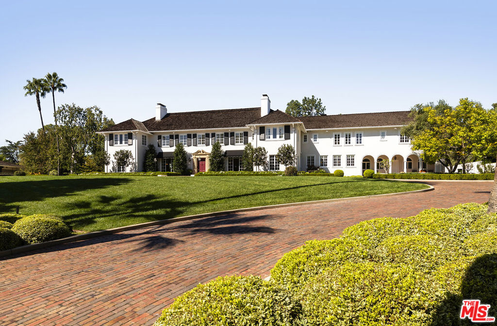 The Knoll House, designed by Myron Hunt and Gordon Kaufmann AIA in 1916, is Pasadena's largest single-family residence. Located in the prestigious Langham Huntington Hotel area, this 100-plus-year-old, 32,000-square-foot estate has been meticulously restored, blending modern luxury with old-world charm. This leafy gated estate delights with original flourishes, including hand-carved moldings, book-matched wood paneling, nine wood-burning fireplaces, and original floors. The grand entry welcomes you with Italian marble floors, soaring ceilings, and Quantum wood windows. An expansive main house offers a spacious flow for everyday living, with a grand living room, a wood-paneled library, formal dining room with Zuber's Passage Italian scenic wallpaper, a chef's kitchen, breakfast room, butler's pantry, restored English Pub, and a family room. In contrast, a separate gallery provides the square footage for lavish hosting, museum-quality art exhibitions, movie premieres, wine tasting, and game tournaments. Enjoy vino from the 2,500-bottle wine cellar, a refreshing tropical beverage from the custom Tiki Bar, or explore six secret doors, some leading to commercial-grade elevators to take you to other areas in the property. The alfresco California lifestyle awaits in the outdoor pavilion, swimming pool, or verdant grounds.