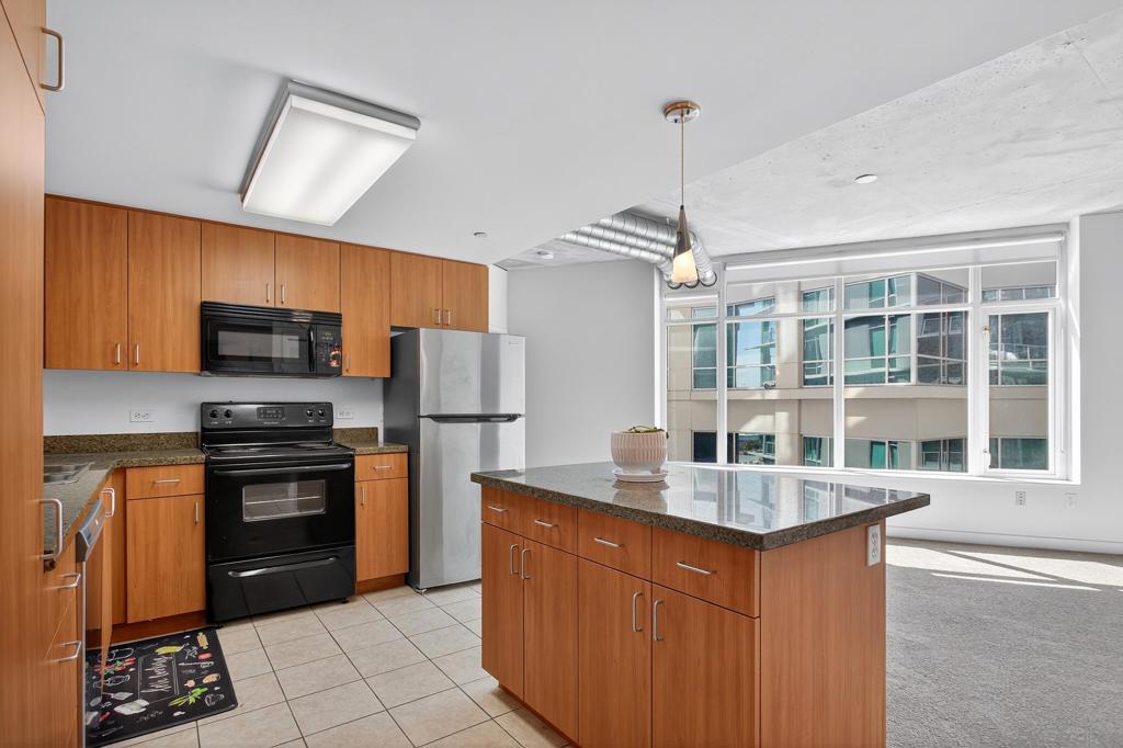 This spacious 2-bedroom, 2-bath condo offers 913 sq ft of contemporary urban living in the heart of East Village. The unit features floor-to-ceiling windows, high concrete ceilings, a private balcony, granite countertops in the kitchen, and a full-size stackable washer/dryer. Residents enjoy Smart Corner amenities including a rooftop hot tub, BBQ and WiFi-enabled lounge area, fully equipped fitness center, and on-site security. Includes 1 assigned underground parking space.