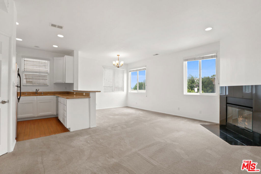 Experience elevated top-floor living in this fantastic 2-bedroom, 2-bathroom Penthouse, 1,160 sq ft corner-unit condo with unobstructed views.This sun-filled penthouse-style home boasts sweeping east and south-facing views, soaring ceilings, and an abundance of natural light throughout. Freshly repainted walls add a warm, inviting feel, while the smartly designed layout offers both comfort and functionality. The spacious living and dining area features oversized windows, a cozy fireplace, and seamless flow into a well-appointed kitchen with stainless steel appliances, stone countertops, and generous cabinet and storage space. The primary suite includes a large en suite bathroom with an oversized vanity, tiled tub and shower, and ample closet space. The second bedroom showcases treetop, city, and mountain views to the south, perfect for a home office or guest space. Additional highlights include an in-unit washer and dryer, two-car tandem parking in a gated garage, and secure building access. Tucked away on a quiet street near the vibrant NOHO Arts District and Toluca Lake West, you're just minutes from top shops, dining, and local culture.