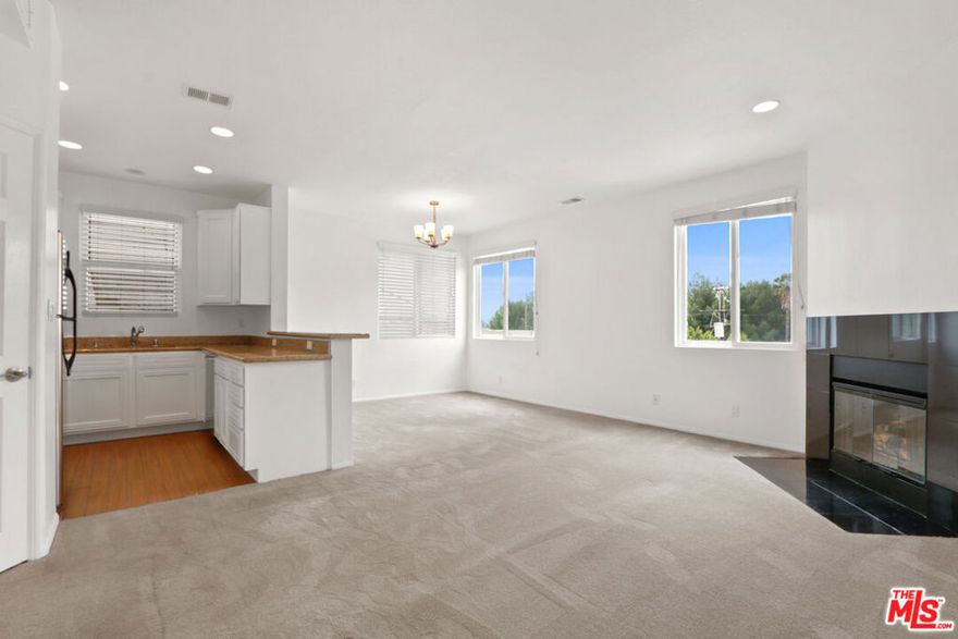 Experience elevated top-floor living in this fantastic 2-bedroom, 2-bathroom Penthouse, 1,160 sq ft corner-unit condo with unobstructed views.This sun-filled penthouse-style home boasts sweeping east and south-facing views, soaring ceilings, and an abundance of natural light throughout. Freshly repainted walls add a warm, inviting feel, while the smartly designed layout offers both comfort and functionality. The spacious living and dining area features oversized windows, a cozy fireplace, and seamless flow into a well-appointed kitchen with stainless steel appliances, stone countertops, and generous cabinet and storage space. The primary suite includes a large en suite bathroom with an oversized vanity, tiled tub and shower, and ample closet space. The second bedroom showcases treetop, city, and mountain views to the south, perfect for a home office or guest space. Additional highlights include an in-unit washer and dryer, two-car tandem parking in a gated garage, and secure building access. Tucked away on a quiet street near the vibrant NOHO Arts District and Toluca Lake West, you're just minutes from top shops, dining, and local culture.