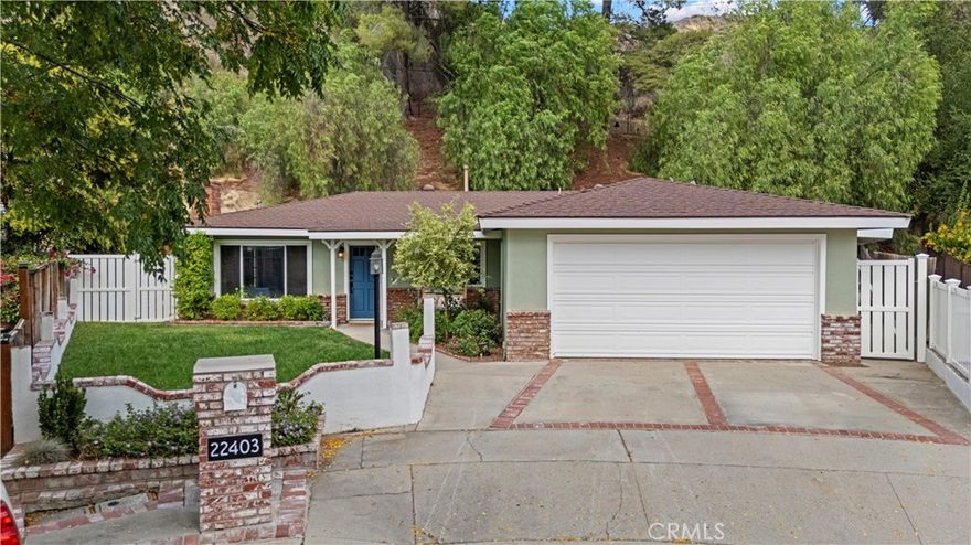 No HOA, No Mello Roos! Tucked at the end of a quiet cul-de-sac in the heart of Santa Clarita, this beautifully updated single-story home offers the perfect blend of timeless charm, smart-home convenience, and high-quality craftsmanship.



Step inside to find brand new flooring and abundant natural light that fills the spacious, open-concept living areas. Designed for modern living, the home features Alexa-enabled smart technology, giving you voice-controlled comfort and efficiency in every room.



At the heart of the home is a truly special craftsman-style kitchen, thoughtfully designed with handmade cabinetry, quartz countertops, a farmhouse sink, walk-in pantry, and a stunning parota wood island that anchors the space—both functional and a one-of-a-kind showpiece.



The living and dining areas are perfect for entertaining, with a classic brick fireplace and seamless indoor-outdoor flow. The primary suite is a private retreat with vaulted wood-beam ceilings, direct access to the screened patio, and a spa-like bath with dual vanities, a soaking tub, glass-enclosed shower, and skylight.



Two additional bedrooms offer versatility for guests, family, or office use, served by beautifully updated bathrooms and INDOOR LAUNDRY for added convenience.



Out back, enjoy multiple outdoor spaces including a custom-built deck, screened patio, and terraced garden beds—all surrounded by mature landscaping and a serene hillside with no rear neighbors.



22403 Los Rouges Drive offers privacy, quality, and modern comfort—an exceptional opportunity in one of Santa Clarita’s most desirable neighborhoods.