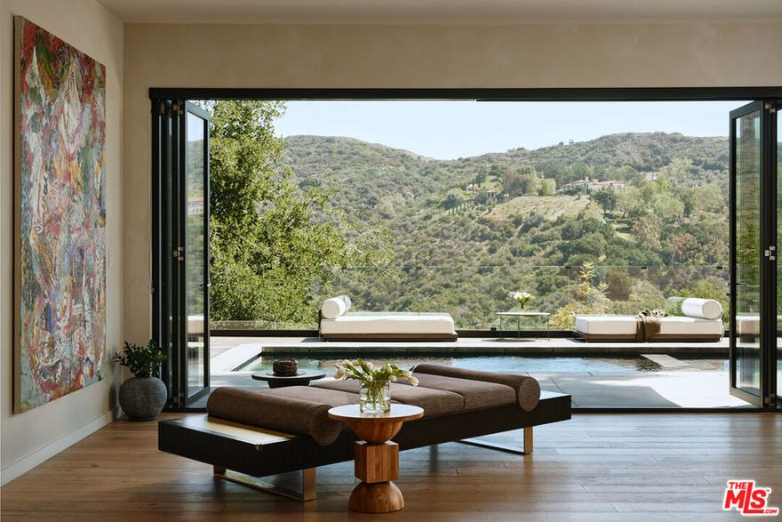 As featured in Architectural Digest, this modern Brentwood estate offers 7 bedrooms, 10 bathrooms, and sweeping ocean and canyon views. Set on a lush, private lot, the residence balances refined architecture with effortless indoor outdoor living. Walls of glass and natural materials flood the home with light and frame the landscape from nearly every room. Multiple patios and connected entertaining areas create an easy flow for hosting gatherings or quiet everyday moments. The chef's kitchen pairs top-tier appliances with clean, modern lines and bold designer details - equally at home for early morning coffee or a lively dinner party. The serene primary suite offers a spa-worthy bath, expansive walk-in closet, private balcony, and warm, curated finishes. Other bespoke features include an intimate, clubroom-style speakeasy, a dedicated gym/wellness center, and a 1,000 sq ft rooftop deck that captures the breathtaking views. Designed for privacy and connection, the home transitions effortlessly between vibrant entertaining and tranquil retreat - California living at its finest.