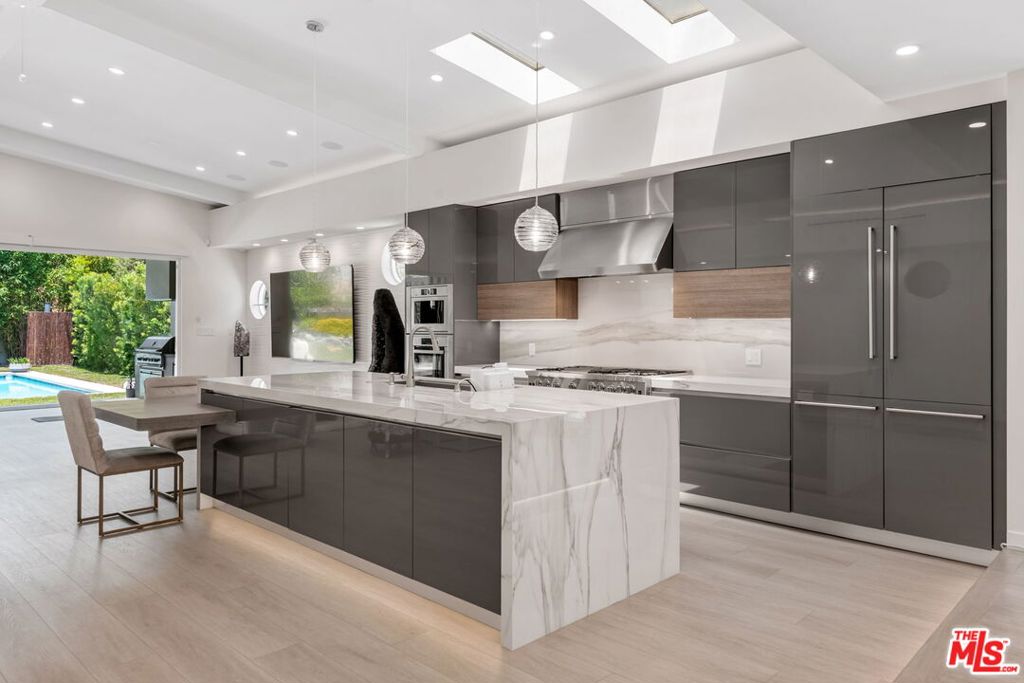 This single-level home has been completely rebuilt and stripped to the bones. Reimagined with high-performance systems and premium materials throughout. Every inch is modernized, A new roof, HVAC, plumbing, electrical, insulation, and windows make the structure feel brand new. Inside, clean architectural lines and wide open spaces define the flow. Vaulted ceilings and oversized sliders flood the home with natural light. The kitchen is fully custom: European cabinetry with massive storage and multiple pullouts, stone slab waterfall island, integrated appliances, double door fridge, oversized range and hood, coffee maker, dishwasher and microwave, a full walk in pantry. The living areas open effortlessly to the outdoors via retractable glass doors that offer multiple combinations.The private area's are anchored on the center hall, an ensuite bedroom at one end, two additional bedrooms share a large modern bath. The primary suite anchors the back of the hall with direct access to the garden, the primary bath offers a spa like experience, with imported stone, dual commodes, a jetted tub, heated towel rack, accent lighting and an oversized dual head shower with steam unit. Outside, the grounds are lush and fully landscaped for privacy and serenity. Mature trees and curated plantings wrap the home in greenery. A modern pool and spa are tucked into the backyard, complete with cabana and outdoor shower. The koi pond/waterfall feature brings a sense of nature, balance and peace. Enjoy all the offerings of living in this close in location. Just a few short blocks through the neighborhood to Beeman Park, featuring tennis courts, basketball courts, BBQ pits, baseball diamond, children's play area. Just a short distance to Erewhon market and shopping at Sportsman Lodge, and all the active dining along Ventura Blvd..easy access to the westside via Coldwater Canyon...Originally developed by a "Healer" as a spec home but ultimately decided to make his own home, time to pass this tranquil sanctuary on to the next lucky steward..