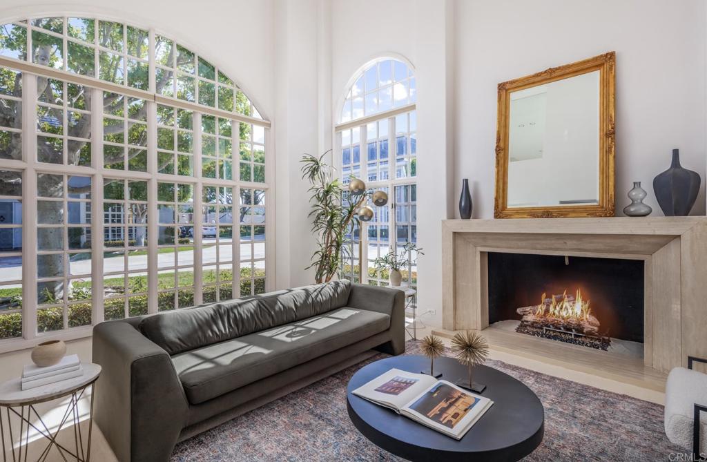 Welcome to this rare and highly coveted corner-unit townhome—one of the few with its own private driveway—in the exclusive, gated community of The Jockey Club, ideally located adjacent to the world-renowned Omni La Costa Resort & Golf Course. Step inside to a truly breathtaking living room, where soaring 20-foot ceilings and dramatic floor-to-ceiling windows flood the space with natural light. A grand fireplace serves as the centerpiece, creating an elegant yet inviting ambiance that’s perfect for upscale entertaining. Just off the main space, a cozy family room offers the perfect retreat for relaxing evenings or hosting guests in a more intimate setting. The gourmet kitchen opens seamlessly to a tranquil, private patio surrounded by lush landscaping—ideal for indoor-outdoor living. With granite countertops, a prep sink, and generous counter space, it’s designed for both style and function. Upstairs, two oversized bedrooms await, including a show-stopping primary suite worthy of a five-star resort. Enjoy room for a sitting area, a spacious walk-thru closet, and a luxurious en-suite bathroom adorned with black-and-white marble, dual vanities, a jetted soaking tub, and a separate shower. Impeccable curb appeal is complemented by mature, manicured landscaping in both the front and back. Community amenities include gated access, a clubhouse, pool and spa, and direct access to the fairways of the Omni La Costa Golf Course. Sophisticated, serene, and simply stunning—this is La Costa living at its finest.