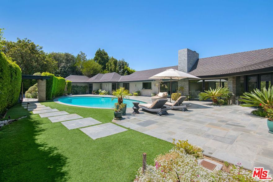 Tucked away on a quiet cul-de-sac just off iconic Mulholland Drive, this unique 4-bedroom, 3-bathroom mid-century home offers an unmatched blend of privacy, serenity, and convenience in Beverly Hills. Situated on a 32k sq ft lot, this elegant residence sits behind a private gated driveway, creating an exclusive retreat surrounded by lush, landscaped grounds and peaceful hillside views. Step inside to discover a light-filled contemporary interior that perfectly balances timeless mid-century design with modern sophistication. The open-concept living and dining areas feature clean lines, oversized windows, and a seamless indoor-outdoor flow, ideal for both quiet relaxation and stylish entertaining. The gourmet kitchen is tastefully appointed with premium appliances, sleek cabinetry, and a large center island. The primary suite offers double glass doors offering access to the outdoor pool area. Three additional bedrooms offer flexibility for guests, a home office, or growing families. Step outside to your private oasis....a large, sparkling pool surrounded by mature foliage and grassy area with multiple lounging and dining areas that invite year-round outdoor living. With its expansive lot, the property also presents an exciting opportunity for an ADU build, offering excellent add-on value and flexibility for future expansion or income potential with close proximity to freeways, shopping, dining and top-rated schools. Don't miss this rare opportunity to own a slice of classic California living re-imagined for the modern lifestyle.