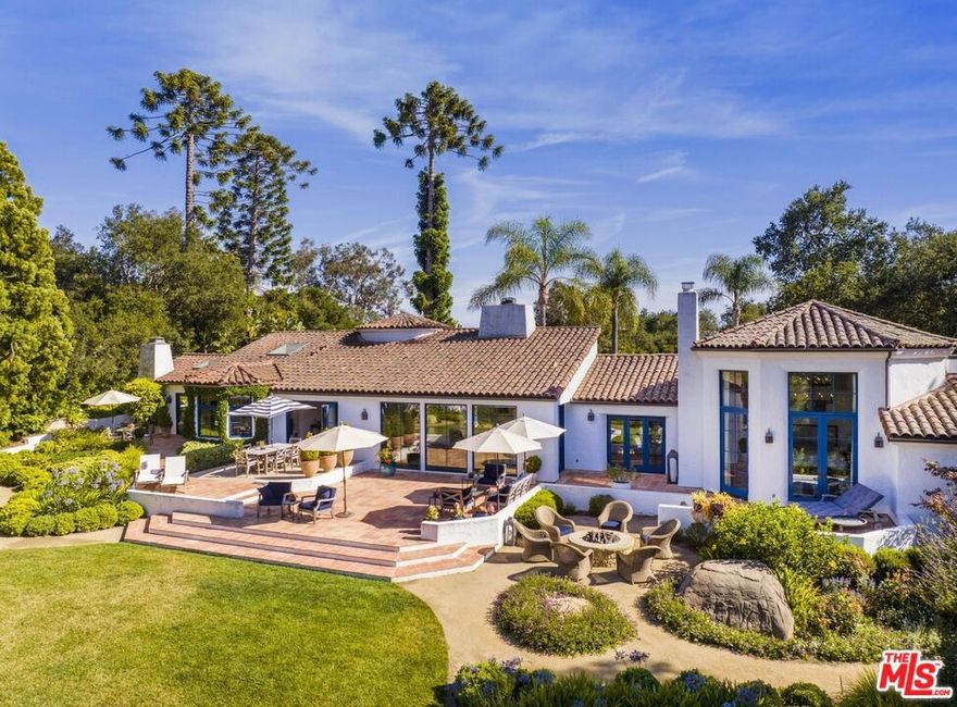 Serene and graceful Mediterranean residence exquisitely designed with a beautiful Spanish-style courtyard, luscious romantic gardens, and open floor plan. Offering sophisticated interiors and exteriors this light and bright 5-bed, 4.5-bath single-story home features two separate wings with spacious living, dining, and great rooms, a gourmet kitchen with island, hardwood floors, vaulted ceilings, skylights, elegant chandeliers, and numerous fireplaces. The luxurious primary suite features a large walk-in closet, office, and en-suite bath. Interior design by Marc Normand Gelinas. French doors from nearly every room lead out to the lush gardens and outdoor patios showcasing expansive mountain views. This timeless residence is a perfect fusion of classic elegance and modern conveniences.