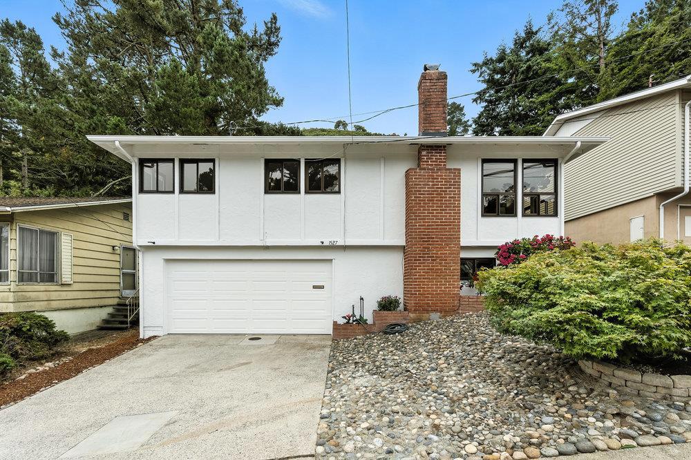 Located in Pacificas sought-after Sun Valley neighborhood, this inviting home offers a rare combination of space, updates, and location, making it a fantastic value for the area. Set on a generous 7,500 sq ft lot, the home features an updated kitchen and bathrooms, fresh interior and exterior paint, and new carpet. The bright living room includes a cozy wood-burning fireplace, while the kitchen is equipped with a gas cooktop and stainless steel appliances. The dining room opens to a sunny deck - ideal for relaxing or entertainingwith stairs that lead down to the expansive, low-maintenance backyard. Downstairs, nearly 400 sq ft of built-out bonus space provides incredible flexibility, whether you're in need of a home office, creative studio, play room, or workout room. The oversized two-car garage includes laundry and a great workshop area for hobbies or weekend projects. With a newer roof (approximately 8 years old) and a prime location just minutes from the beach, scenic hiking trails, schools, and shopping, This home delivers the perfect blend of comfort, convenience, and coastal charm.