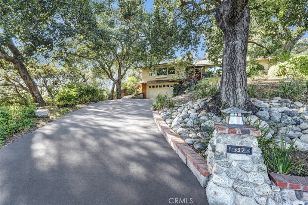 Tucked away at the end of a quiet cul-de-sac in coveted North Monrovia, 337 Meadow Lane offers the perfect blend of privacy, charm, and resort-style living. This 3-bedroom, 2-bath home is nestled among mature oak trees and features a sparkling pool with a spa that cascades into the water by way of a tranquil waterfall—a true backyard retreat. A long private driveway enhances the sense of seclusion, while the beautifully landscaped setting and sweeping views create an atmosphere you’ll never want to leave.
Inside, the warm and inviting layout is filled with natural light, while outside, the peaceful surroundings make you feel worlds away from the city. Yet, you’re just minutes from vibrant Downtown Monrovia, where you can enjoy shops, restaurants, and the lively Friday Night Street Fair. This rare property combines the tranquility of nature with the convenience of in-town living.