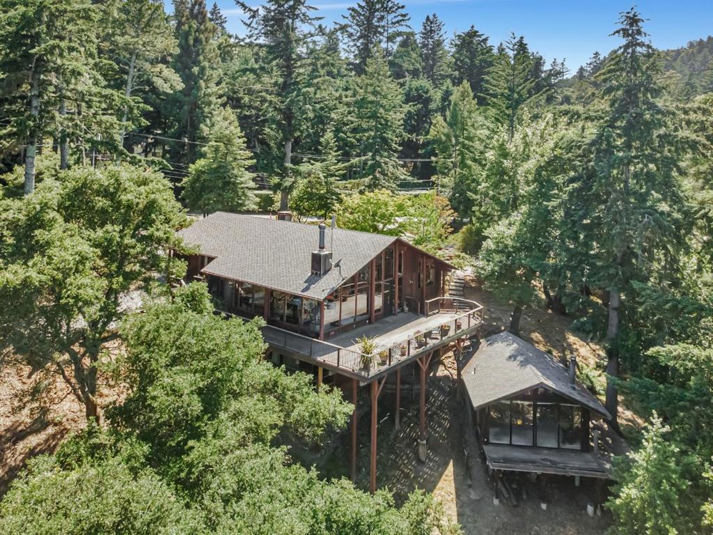 Step inside and step back in time to this to this stunning Henrik Bull-style home in Skywood Acres, where classic charm meets modern comfort. Nestled in a sunny tranquil setting, this architectural gem opens into a breathtaking great room with cathedral ceilings and walls of windows that frame sweeping treetop views. This seamless blend of indoor/outdoor living extends to an expansive deck offering a perfect retreat that harmonizes with nature. Reminiscent of a mountain ski lodge, this 2510 sqft private haven enjoys its own sunny microclimate and offers the ultimate escape, just 14 minutes to 280, 25 minutes to Stanford, minutes from Alices Restaurant, and private access to Wunderlick Park, Portola Valley schools. Main home features a primary bedroom that includes bathroom, dressing room and private office. Main level boasts a well-appointed kitchen, custom wood built-ins, opens to a grand living area. Downstairs 2 bedrooms and bath, 3 car garage with wine closet. Detached guest studio with sleeping loft. 1.5 acre lot includes a former sport court ready for new possibilities Make this getaway your private Shangri-La