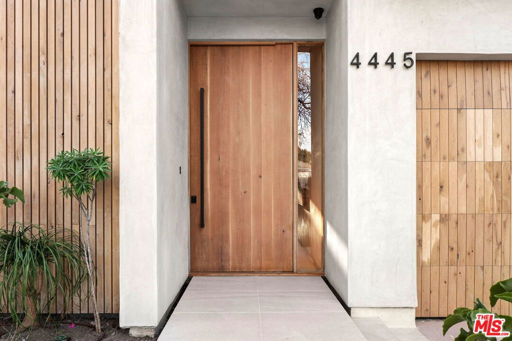 Tucked in the heart of Studio City, this newly built modern farmhouse blends sleek sophistication with natural warmth. Featuring 4 beds and 5 baths in the main house plus a 1 bed/1 bath ADU, the property is designed for both luxury and livability. The main level opens with soaring ceilings, cove lighting, and wide-plank oak floors. A wall of floor-to-ceiling sliders floods the space with light and creates a seamless flow to the outdoor retreat complete with pool, spa, outdoor kitchen, and a private grassy lawn surrounded by lush hedging. The gourmet kitchen is a showpiece, with custom oak cabinetry, LED-lit smoked glass shelving, and built-in Miele appliances including a double oven, coffee machine, oversized fridge/freezer, and hidden exhaust above a 6-burner stovetop. The oversized island invites gathering and effortless entertaining. Upstairs, the vaulted primary suite features wood-paneled ceilings, a fireplace, a private terrace, a spa bath, and a custom walk-in closet. Two more en-suite bedrooms and a full laundry room complete the upper floor. Downstairs, an additional en-suite bedroom offers flexibility for guests, a home office, or gym. The detached ADU mirrors the home's architectural warmth, with pitched ceilings, sliding doors, and its own full kitchen ready to become whatever you need it to be: a guest retreat, a poolside escape, a creative studio, or your ultimate entertaining space. Every inch of this home was crafted with intention refined, functional, and built to inspire.