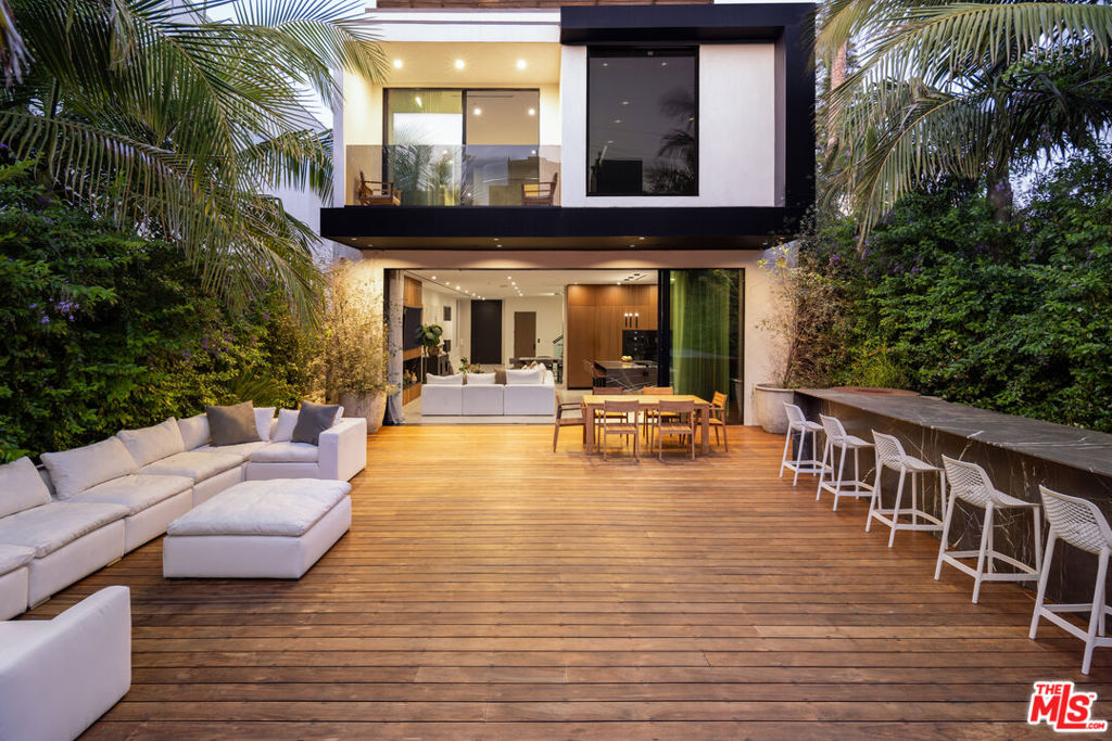 Welcome to 515 N Harper Ave - a modern 4-bed, 5-bath retreat that blends warmth, style, and effortless indoor-outdoor living. The main level features soaring ceilings, sliding glass doors, and open living perfect for entertaining. Chef's kitchen with custom Italian cabinetry, Miele appliances, and an adjacent powder room. The primary suite offers a walk-in closet and spa-like bath. A private elevator connects all levels from the home theater to the rooftop deck with Hollywood Hills views. Outdoors, enjoy the pool/spa, a full bar with seating for 10+, built-in grill, and lush landscaping. Moments from the Pink Wall, Melrose shops, and West Hollywood's best dining and nightlife.