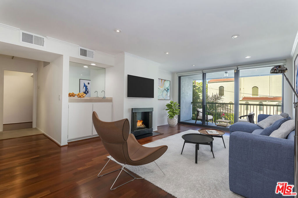 Located in Doheny Terrace, one of West Hollywood's most amenity-rich condominium buildings, this quiet and spacious 1,257 sq.ft. 2BR/2BA condo sits at the back of the complex with a large private balcony offering peaceful outdoor space. Inside, the unit features hardwood floors throughout, a living room with a fireplace and wet bar, motorized blinds, and plenty of closet space. The layout includes a generous primary suite with an en-suite bath and ample storage, plus a well-sized second bedroom and an adjacent full bathroom. The kitchen has Travertine countertops and flooring and connects to the dining area. A breakfast bar area provides additional functionality. Newer windows throughout and a newer Fleetwood sliding glass door. The unit has been freshly painted along with newly-installed LED lighting in the bedrooms. The building, which sits in the highly sought after Norma Triangle, has amenities including a sparkling pool, sauna, gym, and laundry facility (in-unit laundry can be ADDED with HOA approval). Just blocks from the Sunset Strip, Beverly Hills, and the best of WeHo's dining, shopping, and nightlife. 2 gated side-by-side parking spaces (near an elevator) and low HOA dues of $682.40/mo., which includes earthquake insurance for the building. Seller to pay pending assessment, which is $87/mo. for building improvements. Photos are virtually staged.