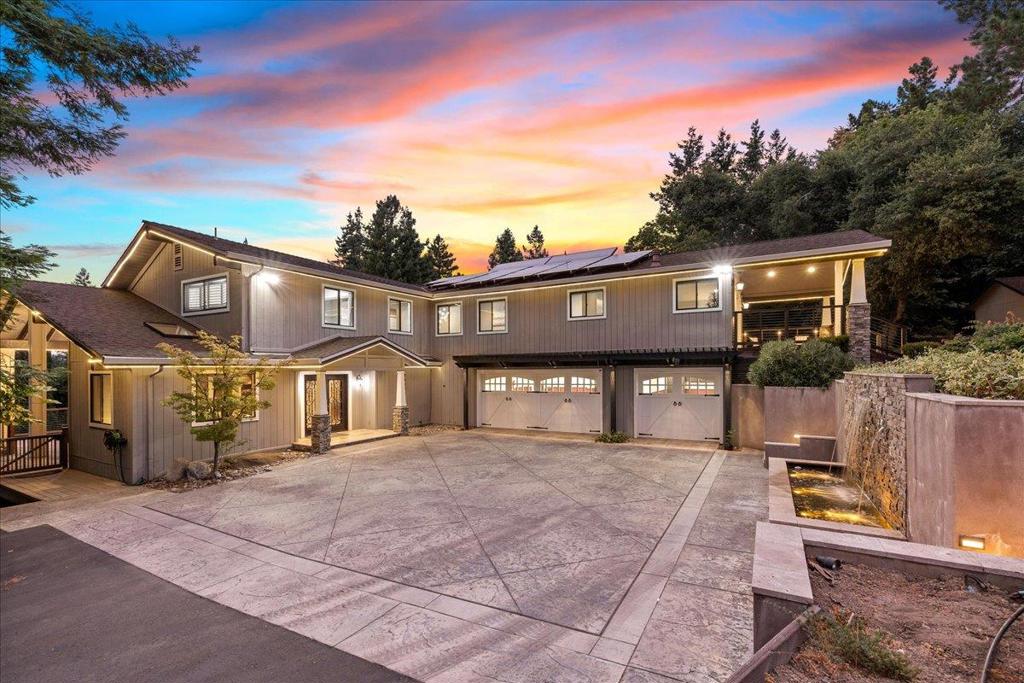 Nestled on a 2.46-acre lot, this architecturally stunning retreat blends country charm with modern luxury, just minutes from Downtown Los Gatos. Enter through striking double doors into a travertine-tiled foyer, leading to a family room with vaulted wood-inlay ceilings, hardwood floors, and expansive forest views. The high-end epicurean kitchen showcases JennAir appliances, maple cabinetry, granite counters, and a breakfast bar including a prep sink and an induction fondue cooktop. The home features 4 bedrooms, a dedicated den, and a versatile loft (5th bedroom/craft room). The primary suite offers vaulted ceilings, a gas fireplace, dual walk-in closets, private deck, and a modern spa-like bathroom with radiant floors, floating vanities, and a steam shower. Smart amenities include triple-zone NEST climate control, Sonos-controlled speakers, owned solar, a tankless & a solar water heater, and a private well. Enjoy a finished 3-car garage and a climate-controlled gym. Multiple decks invite relaxation, while a gazebo-covered hot tub sits beside a cascading waterfall and serene lily-pad pond. A pellet stove-warmed barn/workshop welcomes year-round projects. Served by top schools, including Los Gatos High, this retreat offers nature, technology, and craftsmanship in perfect harmony.