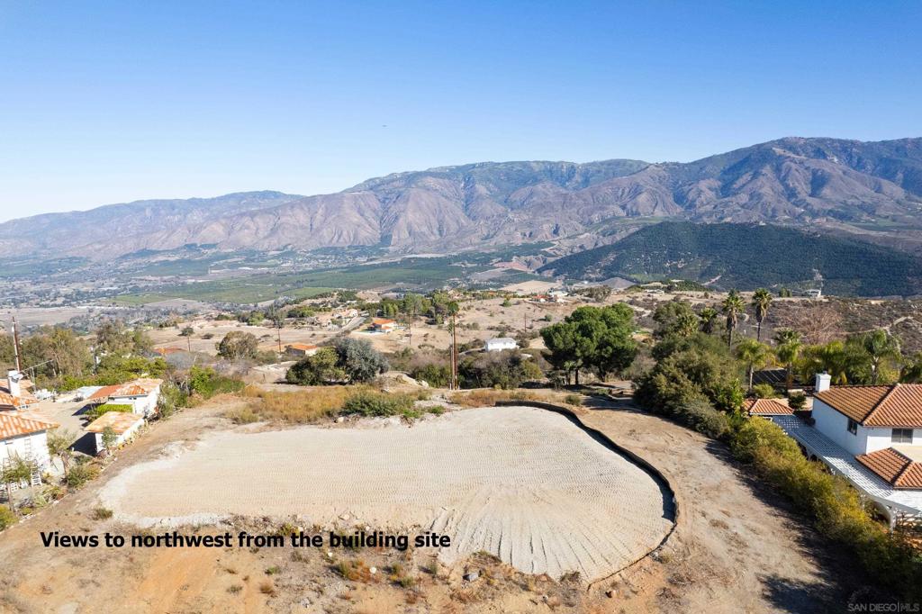 Words Don't Do Justice ... Perched along a rim that defines the eastern edge of Valley Center before dropping into the deep and lush green Pauma Valley, this extraordinary piece of land offers an unparalleled setting for your future home. As you stand on the property, you’ll be captivated by 360-degree panoramic views. Laid out in full view to the north and front of the property is the grand and majestic Palomar Mountain range often snowcapped in the winter. Southwards are the peaks of eastern San Diego with the serene valley and rolling hills of Valley Center stretching westward. Located on a private gated road and part of a small community that shares the secret of this ridge, you’ll experience the peace, quiet and beauty of nature usually found only in truly remote locations. Just minutes from ... see supp Cole Grade Rd you’ll enjoy quick access to businesses on one of the most direct routes in town. This parcel is at the highest point of the rim and is dotted with lush native vegetation and striking rock outcroppings, adding to its natural beauty. Preliminary grading has already been completed, ensuring a clean and clear building site where the risk of costly rock complications have been removed. A one-inch water meter has been paid for but is not installed. Power and a fire hydrant are nearby. Parcel Map 5122 previously approved the property for a standard septic system to support a 3BR bedroom residence. To mitigate any risk of relying on this aged certification, the owner has paid for a new 5BR civil engineer prepared septic design with 3BR option, ready for approval when closer to construction. There is ample space for a resort-style pool, perfect for relaxation and entertainment under the sun. Living here means embracing the vibrant lifestyle of Valley Center, with its crisp mornings and breathtaking sunsets. It offers the peace and tranquility of country living, all while being close to a variety of outdoor adventures like hiking, horseback riding, camping, and golfing. For those seeking a bit of excitement, nearby casinos provide entertainment, while local wineries offer wine tasting experiences. Plus, the iconic Bates Nut Farm is just around the corner, a delightful spot for both kids and adults to explore. Valley Center is the jewel of San Diego and known for being one of the safest places to call home in the county. This land is more than just a location. It’s an opportunity to immerse yourself in the beauty and richness of Valley Center.