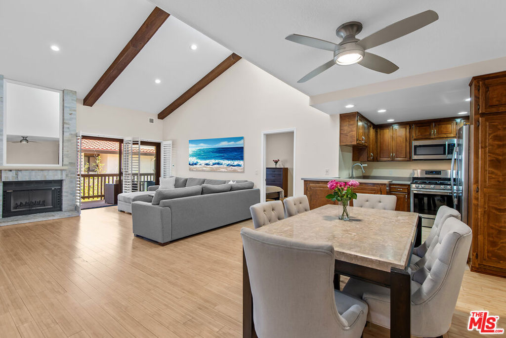 Highly sought-after 3-bedroom, 2-bathroom sun drenched penthouse, ideally situated on an interior corner of the coveted Villas del Rey community. This top-floor residence impresses with soaring vaulted ceilings accented by wood beams, multiple skylights that bathe the space in natural light, and the perfect blend of style and function. Step inside to find bamboo flooring, recessed lighting, plantation shutters, and a striking custom stone fireplace anchoring the spacious living area. Enjoy effortless indoor-outdoor living with a private wrap-around balcony accessible from both the living room and the primary suite. The updated chef's kitchen is thoughtfully designed with stainless steel appliances and abundant cabinetry, perfect for cooking and entertaining. The primary suite features vaulted ceilings, balcony access, a walk-in closet, and a private en-suite bath. Two additional well-sized bedrooms, central air and heat, in-unit laundry, and two parking spaces add to the home's comfort and convenience plus an exceptionally large private storage room. Villas del Rey offers resort-style amenities including a sparkling pool, two spas, saunas, tennis courts, fitness center, clubhouse with full kitchen, ample guest parking, and evening security. All these just moments from the beach less than half a mile away!