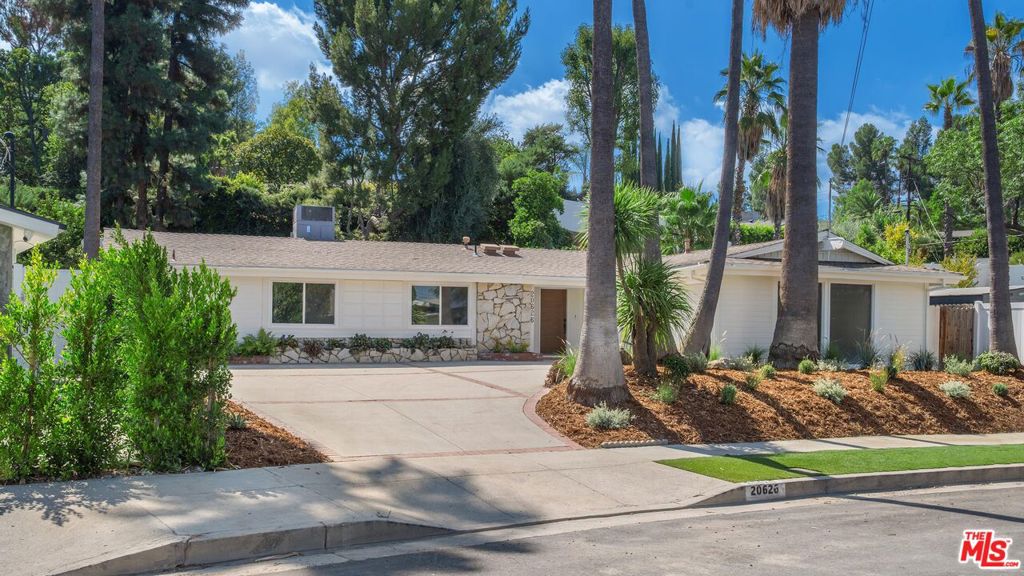 Set on a peaceful street in Woodland Hills, this beautifully reimagined single-story residence showcases modern sophistication, thoughtful upgrades, and a seamless, light-filled layout. Offering 4 bedrooms and 3 bathrooms, the thoughtfully designed open floor plan is enhanced by vaulted ceilings, warm floors, and an abundance of natural light. Before stepping inside, the property greets you with towering palm trees and an expansive driveway that set a welcoming tone. At the heart of the home, the recently upgraded custom kitchen features a Wolf 6-burner range, new appliances, prep sink, wine and beverage fridge, and sleek countertops with ample cabinetry. Seamlessly connected to the dining and living areas, the open-concept layout is anchored by a contemporary gas fireplace and expansive sliding glass doors that invite a true indoor-outdoor flow. The primary retreat boasts generous closet space and a spa-like ensuite bathroom with dual floating vanities and a glass-enclosed step-in shower. The other bedrooms and bathrooms continue the modern design. The backyard is a private oasis overlooking a lush hillside, complete with a covered patio for al fresco dining, a putting green, and a resort-style pool, perfect for relaxing and entertaining. Moments from Westfield Topanga, The Village and easy access to the 101 freeway, this home offers the best of California living in an unmatched location.