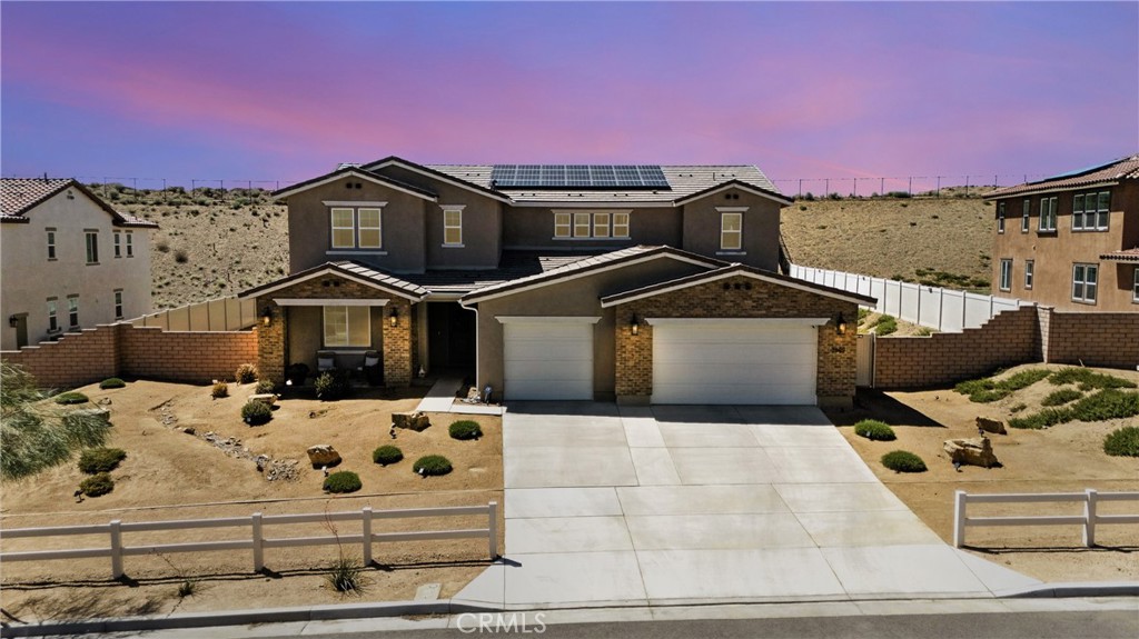 Luxury, space, and smart design define this immaculate estate nestled in the sought-after community of Eliopulos Ranch in West Palmdale. Built in 2022, this 5-bedroom, 3-bathroom residence offers a rare combination of modern elegance, energy efficiency, and open-concept living on a generous 21,833 sq. ft. lot.
At over 4,400 square feet, the home welcomes you with a sprawling floor plan ideal for both entertaining and everyday comfort. The heart of the home is the chef-inspired kitchen featuring a massive quartz island with seating for six, premium white shaker cabinetry, stunning glass subway tile backsplash, and top-of-the-line appliances including an induction cooktop and double wall ovens. A built-in microwave, stainless steel dishwasher, and extensive cabinet storage complete the space.
Open to the kitchen is the great room, flooded with natural light and centered around a sleek electric fireplace. From cozy evenings to large gatherings, this living area offers comfort and versatility with seamless flow into the dining room and outdoor access.
The primary suite serves as a private retreat with a spa-like en suite bathroom featuring a huge walk-in shower with dual showerheads, a built-in bench, dual vanities, and custom mirrors. Secondary bedrooms are spacious and well-appointed, offering flexibility for guests, home offices, or a gym. Additional Features Include: Energy-efficient solar system built into the home; Dual-zone HVAC system for precise climate control; Electric vehicle charging station in the 3-car garage; Luxury vinyl plank flooring throughout; Modern pendant lighting and recessed LED lighting; Laundry room with built-in storage and folding space; Extra-deep driveway with custom hardscape.
With no rear neighbors, the backyard offers direct access to scenic hiking trails, peaceful nature views, and endless possibilities for outdoor living.
This move-in-ready masterpiece offers a lifestyle of modern convenience, sustainability, and tranquil beauty, all within minutes of top-rated schools, shopping, and commuter access.