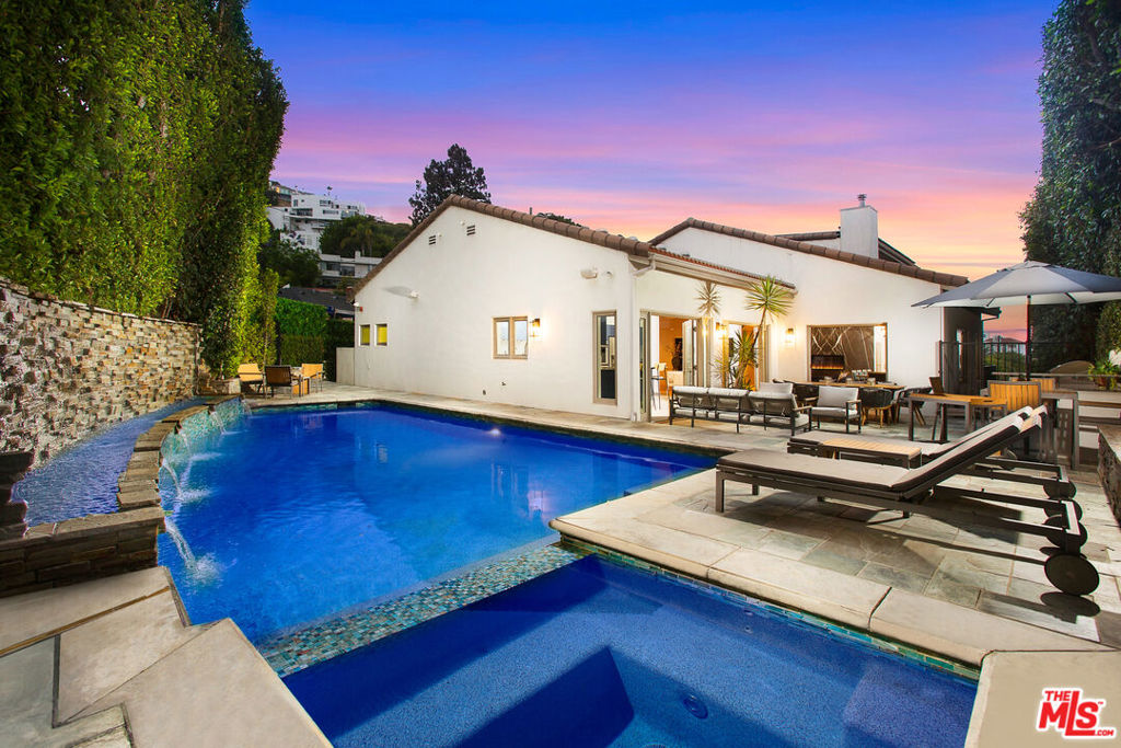 Establish yourself behind the gates of this wonderfully elegant and spectacularly beautiful one of a kind 5 bedroom estate. The foyer's gorgeous inlaid floor is your entree to open plan living spaces where the living room with its dramatic fireplace connects with the formal dining room and flows into the breakfast nook and the Snaidero kitchen, custom designed by Pininfarina which opens seamlessly onto the massive terrace with BBQ, outdoor dining and seating areas that wraps around to the sparkling pool and spa with lounges for unparalleled indoor-outdoor entertaining and recreation. Situated behind the living room fireplace is the family room with piano that opens onto a wrap-aound sun deck with fire pit for your comfort on moonlit nights and cool winter days. Two en suite bedrooms, a guest bathroom, and library complete the main floor experience. Climb the stairs to the top floor primary suite features breathtaking views, a private balcony, custom hardwood cabinetry, and a walk-in closet. The primary bath offers you a claw foot tub and large steam shower. A large office or seating area with its own private bath is adjacent to the primary suite. Completely redesigned and rebuilt, the lower level provides you and your guests an en suite guest room, gymnasium, luxurious screening room, laundry room, storage areas, and a private patio with a grassy yard. The finest materials, craftsmanship and thoughtful attention to detail are used throughout this immaculately bespoke home including: including handmade custom hardwood cabinetry and doors, highly stylized tile and fixtures, and stunning inlaid floors. The grounds are exquisitely landscaped with mature and unique botanical plantings for your dining, grilling, playing or relaxing pleasure. Solar panels and a generator give you the ability to be nearly self-sufficient off the grid while prominently placed just minutes above the famed Sunset Strip.