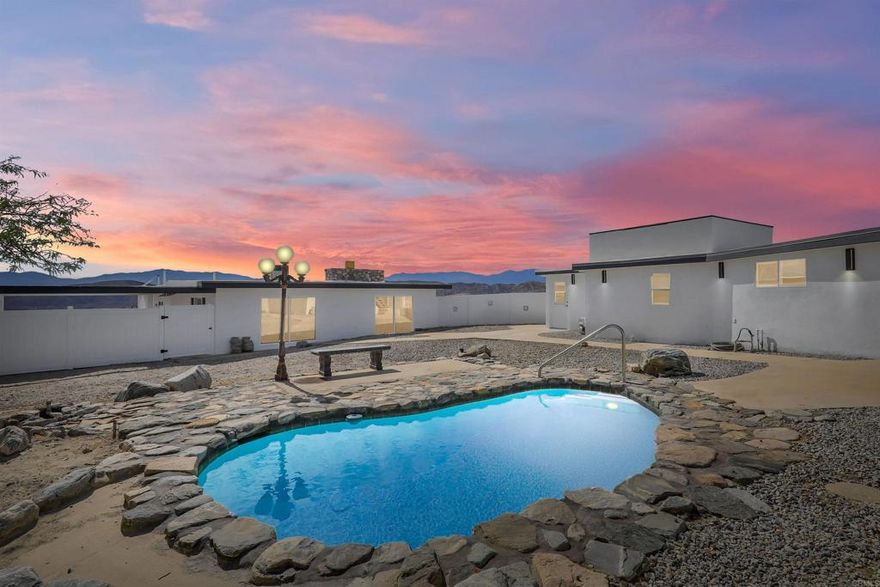 This rare desert retreat sits on 4.75 acres and features a fully renovated main house and ADU, a private natural hot spring pool, a rooftop deck, and horse-friendly zoning. Designed with both lifestyle and investment in mind, the property perfectly balances comfort, versatility, and the tranquility of desert living. The main residence showcases an open-concept layout with beautiful natural light, warm finishes, and a seamless connection between indoor and outdoor spaces, ideal for relaxing or entertaining. The detached ADU includes a full kitchen and private living area, offering flexibility for guests, extended family, or short term rental income. Outside, enjoy your own private resort experience with a natural hot spring fed pool, a standout feature shared by very few private residences in the entire Coachella Valley. The rooftop deck is the perfect place to unwind, take in sunsets, and soak up the spectacular mountain and desert views. With room for horses or future expansion and a location just minutes from Palm Springs and Joshua Tree National Park, this property combines modern living, strong income potential, and the unmatched serenity of the desert lifestyle.