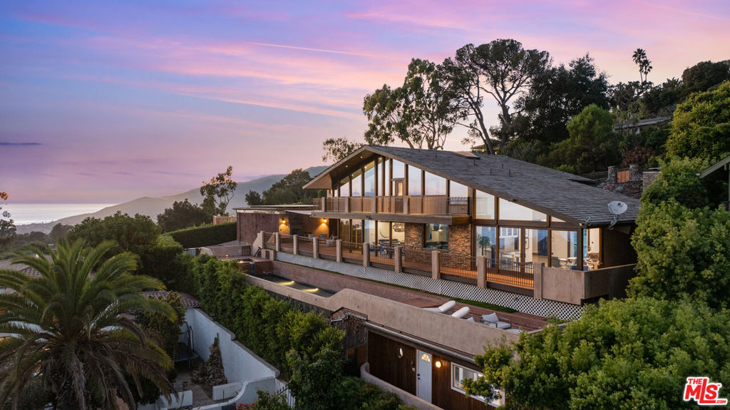 Breathtaking Pacific Palisades Mansion with Panoramic Ocean Views! Welcome to this magnificent 6-bedroom, 8.5-bathroom estate designed by the renowned architect Ray Kappe, offering unparalleled panoramic views from Downtown LA to Catalina Island, the Queen's Necklace, and the beaches of Malibu. Situated in the heart of Pacific Palisades, this stunning property is located moments from hiking and biking trails and all the best the neighborhood has to offer. Remodeled in the early 2000s, this home sits above the serene grounds of Lake Shrine, boasting the best views in the neighborhood. Floor-to-ceiling windows throughout capture the sweeping coastline, creating an incredible setting for both private relaxation and entertaining.The heart of the home features a fully equipped cook's kitchen with an open-concept design that flows seamlessly into the formal dining area, perfect for hosting. Additional highlights include multiple family rooms, a media/screening room, an exercise studio with an en suite bathroom, maid's quarters, and a custom wine cellar with a tasting area. Outdoors, enjoy the expansive deck overlooking the Pacific, with direct access to the lap pool and spa below a perfect backdrop for sunset gatherings or lounging in the sun. The two luxurious primary suites offer breathtaking ocean views, while the remaining three suites all include private en-suite bathrooms. This estate is equipped with an Enphase Solar Energy system for independent energy efficiency. The property includes a separate 3-car covered garage and a spacious 50' x 75' lower parking area capable of accommodating up to seven cars plus an RV, providing exceptional convenience. A charming guest house with a kitchenette and bathroom sits below the pool area, offering a peaceful retreat for guests. Experience luxury coastal living in this Zen-like atmosphere exceptional one-of-a-kind Pacific Palisades home, offering an unmatched blend of architectural elegance, modern amenities, and sweeping ocean views.