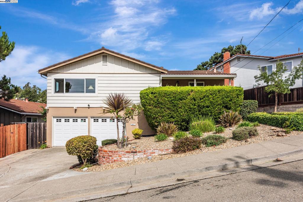 Step into this lovingly maintained home in a peaceful neighborhood where warm hardwood floors guide you through bright, comfortable living spaces. Sunlight filters through energy-efficient dual-pane windows — including premium Andersen windows — creating a cheerful, quiet interior while helping reduce utility costs. The updated kitchen is a chef’s delight with quartz countertops, a tumbled-tile backsplash, built-in gas cooktop and a built-in self-cleaning oven. A generous work island centers the space and opens to an eating area, where sliding glass doors lead to a private deck overlooking serene hilltop views — perfect for morning coffee or evening entertaining. The owner’s suite offers privacy and convenience with mirrored wardrobe storage and a recently remodeled bathroom. Downstairs, a spacious family room provides flexible living with direct access to a landscaped backyard, ideal for indoor-outdoor living or play. An additional downstairs bedroom and full bath make a comfortable home office, guest suite, or au pair quarters. The oversized attached garage includes abundant storage and there’s clear potential to expand or reconfigure spaces to suit your needs. Located minutes from transportation routes, this home blends everyday convenience with quiet suburban charm.