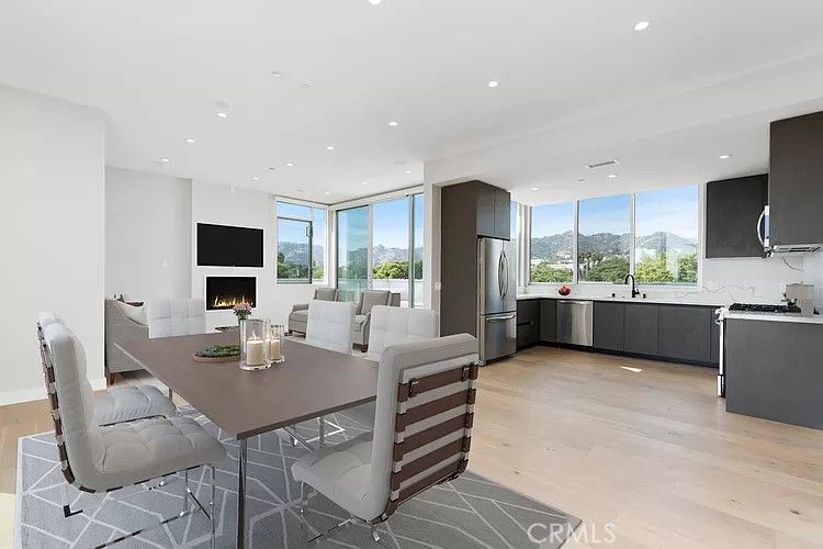 Epitomizing ultramodern luxury, this captivating penthouse in West Hollywood is a visionary masterpiece with unforgettable views reaching the Hollywood Sign. Spanning the entire 2,273 sqft top level of a high-performance building, this newly constructed condominium with smart technology showcases a distinctive style and palette that highlights its aesthetic beauty. Flooded with natural light from expansive glass, elevated living spaces are framed by floor-to-ceiling windows and retractable doors, offering an effortless indoor-outdoor lifestyle. A stunning top-of-the-line kitchen with quartz and stainless accents opens to an elegant dining and living area, creating a fashionable venue for entertaining. Inspired by the ethos of five-star resorts, dual primary suites expand to include tailored closets and lavish baths. Finished with muted European oak floors, secure parking, and multiple decks, this sleek home is the apex of jet-set chic. Soak up the sun or revel under the stars on the private 1,000 sqft rooftop deck oasis, which features a fireplace, television and bubbling spa tub. Craft mouthwatering meals on the stylish outdoor kitchen barbecue and dine alfresco with the Hollywood Hills as your backdrop. Moments from L.A.’s legendary entertainment, this picturesque environment celebrates a high walk score of 93. Surrounded by the Sycamore District and blocks from the epicenter of iconic landmarks, the locale embodies the essence of Hollywood.