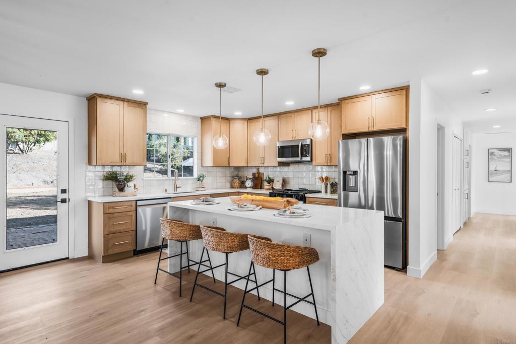 Welcome to a completely & tastefully REMODELED single-level home perched on a spacious .53-acre lot! This stunning 4-bedroom, 2-bath, 2,080 sq. ft. property boasts a newly designed OPEN CONCEPT floor plan, perfect for modern living. The modern, bright kitchen is a chef's delight, featuring Oak Shaker Cabinetry, Quartz counters & island, a designer backsplash, and brand new appliances & fixtures. Enjoy stunning vinyl plank flooring and new baseboards throughout, complementing the oversized living, dining, and family rooms filled with abundant natural lighting and a brand new electric fireplace. The luxurious Primary Bedroom offers a new bathroom, spacious closet, and private backyard views. The two additional beautifully appointed and newly remodeled bathrooms, along with three generous secondary bedrooms, provide ample space for family, office, or flex use. This home has undergone extensive upgrades, including a brand new HVAC system, rebuilt septic system, new plumbing with a tankless water heater, updated electrical, and a 2-car garage with Epoxy flooring. NO HOA! The hard-to-find backyard offers endless possibilities with a large concrete pad, mature trees, and steps to an upper level for a possible ADU, workshop, play area, or pickleball court! Enjoy easy access to I-15, Trader Joe's, Major Market, JIMBOS, and Brigantine Restaurant. The home is also near Felicita Park with beautiful trails, schools, and world-class healthcare. This home is a true gem, ready for its new owners to enjoy the benefits of a beautifully renovated home.