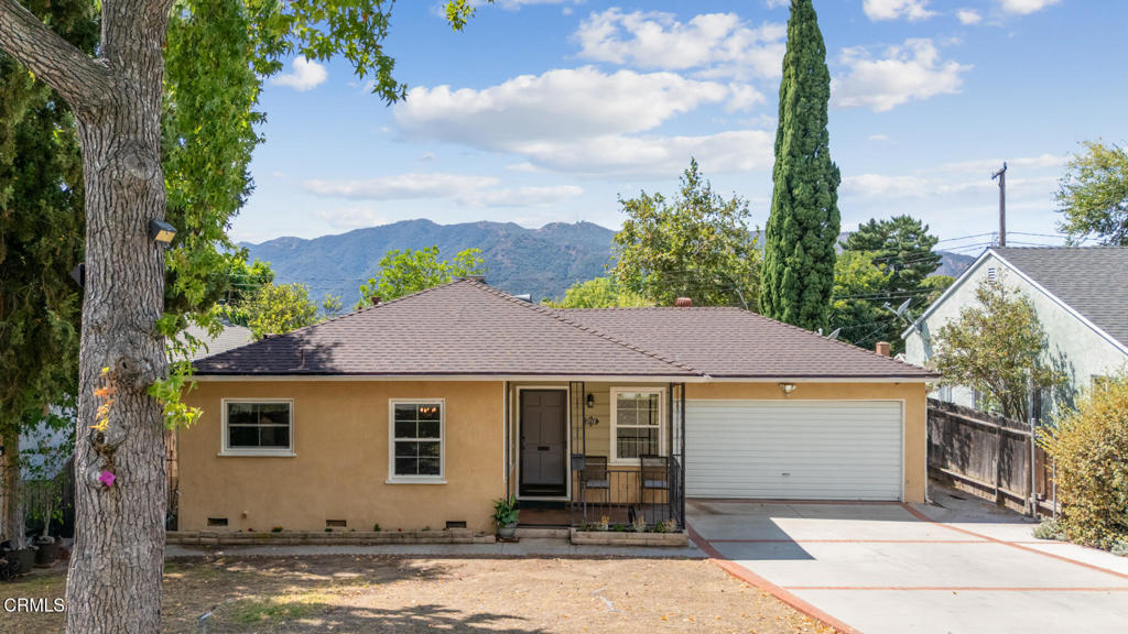 A word about this beautiful home's location: About 2,000 feet above sea level and away from the freeway, so it's quiet. There are no street lights so at night it's dark; there is little light pollution. The street is lined with mature trees on both sides and has little traffic. The San Gabriel Mountains are prominent to the north, as are the Verdugo Mountains to the west. Now step into this American Dream home: There is an open living room/dining room area with laminate flooring and double-pane, UV-coated vinyl windows. A wrought-iron chandelier hangs over the eating area. The updated kitchen has laminate floors, recessed lights, custom wood cabinets, a double porcelain sink with buffed nickel faucet and a window behind the sink offering a front yard view, attractive Formica counters and backsplash, Samsung stainless steel 5-burner stove, Samsung built-in microwave over the stove, and a Samsung stainless steel refrigerator. Next to the kitchen is a laundry/pantry room with recessed lights, LG stackable inverter direct drive motor washing machine and steam dryer. Off the hallway are two bedrooms and a full bathroom. One bedroom has a ceiling fan/light and two large double-pane windows for plenty of light. Both bedrooms have good-sized closets. The upgraded bathroom has an American Standard toilet, a vanity with sink, and shower over the bathtub. The large primary bedroom has a ceiling fan/light, crown and baseboard molding, walk-in closet and updated bathroom with walk-in tile shower with seat and glass door, a vanity with sink and Toto toilet. There's also a family room with sliding glass doors to the fully-enclosed backyard. There are two backyard patios, one with a fire pit to relax around and enjoy the view of the Verdugo Mountains, the other for outdoor dining. There's also a flat grassy area for play or gardening. The front yard has a flower bed alongside the house. Also, there's an attached two-car garage with additional storage shelving. This home is part of the award winning La Crescenta schools, has easy freeway access, is in walking distance to Dunsmore Park with walkable streets, and near Foothill Blvd retail. It's the perfect home!