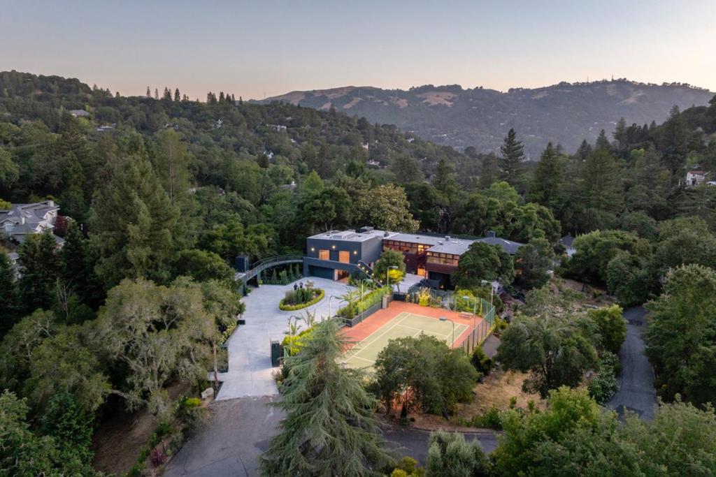 Luxury living within the prestigious Orinda Country Club area is where this resort-like family compound awaits. Nestled atop a level hill lot, this residence offers unparalleled privacy and a bright, functional floor plan--tailored for entertaining guests and sophisticated living. A 5 car garage ensures ample space, while inside, high ceilings create an ambiance of grandeur. Four en-suites provide lavish accommodation, with the primary bedroom features two walk-in closets. Find solace in the tranquility of the library, or entertain in the theater/event room. Stay active in the gym complete with sauna, or simply relax beside the pool and elegant water features. Unwind in the hot tub or engage in a friendly competition on the lighted tennis/basketball court. Beyond the amenities lie lush gardens and koi ponds with a soothing waterfall all contributing to the serene atmosphere of this exceptional retreat. For guests seeking privacy, the detached guest quarters offer comfort and seclusion. Savor the views as you revel in your own oasis, while remaining conveniently close to The Villages, Downtown Orinda, BART, and highways. Just a short drive to San Francisco, Oakland, and airports, this extraordinary Orinda family compound perfectly balances luxury living with everyday convenience.