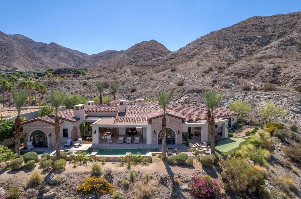 This stunning desert estate is strategically located in the prestigious development of Mirada Estates. This 5BD/5.5BA home boasts 6,033 square feet of living space, including an office, home theatre, and attached two-room guest house. Upon entering, you instantly notice the panoramic mountain and valley views through the walls of sliding glass that open the home to the inside/outside lifestyle. Arguably the best-elevated views in the desert. Custom finishes throughout. The kitchen includes a sub-zero refrigerator/freezer, Wolf oven, Dual dishwashers, a Well-appointed outdoor kitchen, and a Temp-controlled wine cellar.Great for hosting parties and entertaining. The main suite offers views of the city lights and surrounding mountains, spacious closets, dual sinks, and a large walk-in shower. The yard is perfectly appointed with a private courtyard with a fireplace and water features. A large pool overlooks the valley floor and mountain views, a fire pit, a misting system, water features, putting green, and plenty of places to bask in the sun, eat dinner, or have an intimate conversation with friends. You have the perfect location within walking distance of the Ritz Carlton, which includes multiple restaurants and entertainment. This is one of the most elegant desert rentals available.