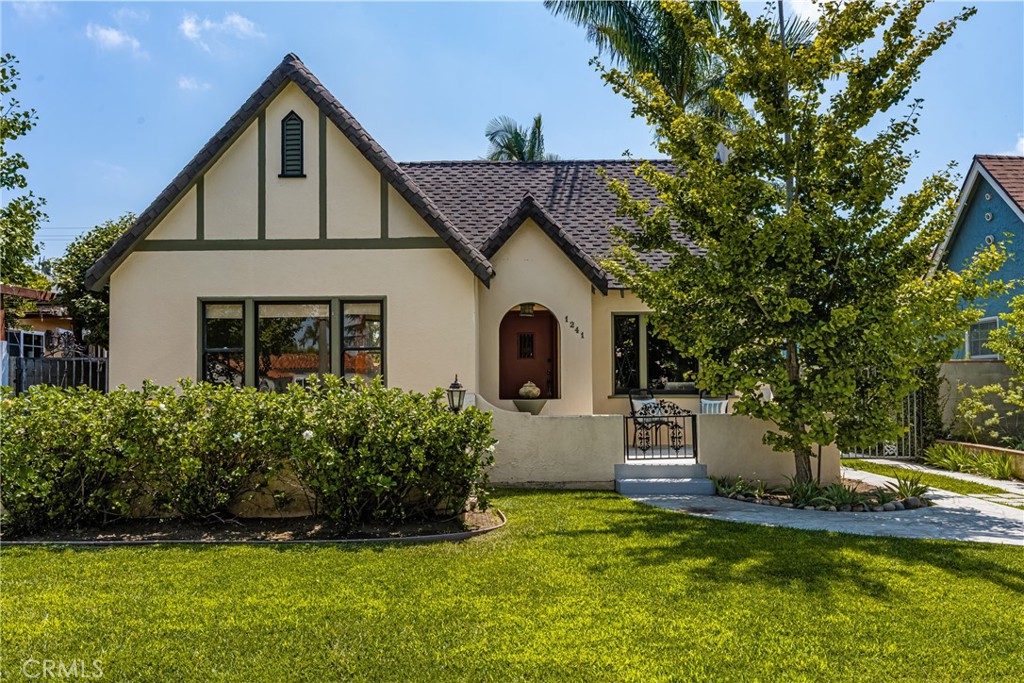 This beautifully preserved 1929 home in Santa Ana’s historic Wilshire Square blends vintage charm with modern amenities. Original hardwood floors, mahogany molding, and wood-framed windows with diamond-pattern glass greet you at every turn. The living room features an arched decorative fireplace, while the formal dining room shines with an antique chandelier. The spacious kitchen boasts soapstone countertops, an O'Keefe & Merritt gas range, and a breakfast nook. Two light-filled front bedrooms share a classic bath with a tub, separate shower, and original built-in storage. The private rear suite, with its own entry, tiled shower, and half bath, offers versatility as a home office or creative space. French doors lead to a lush, landscaped garden with an antique soaking tub. The home also includes a separate laundry room, updated systems like central AC and a tankless water heater, plus plenty of storage. Situated on a quiet, tree-lined street, this home is part of a vibrant community known for its historic charm and neighborhood pride. Don't miss out—call to see this unique gem today!