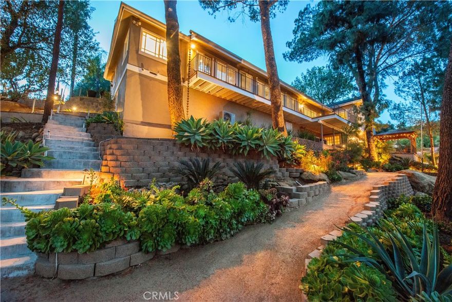 Discover an exquisite hidden gem tucked away in the picturesque hills of Chatsworth—an unparalleled retreat offering the ultimate in privacy, serenity, and natural beauty. This rare & unique executive compound is a dream come true for those seeking a tranquil escape w/breathtaking 270-degree panoramic views of LA. Situated on an expansive 26,461 sq/ft lot, this stunning property is a masterpiece of thoughtful design & modern luxury.  Newly landscaped grounds are adorned w/native plants, enchanting landscape lighting, calming fountains &  peaceful walking paths, all meticulously maintained w/an efficient drip irrigation system. A grand horseshoe driveway, secured by double electric gates, provides ample space for over a dozen vehicles, along with additional room for recreational toys.Blending modern farmhouse aesthetics with classic Nantucket charm, this home is designed for both sophistication & comfort. The custom front door opens to a captivating foyer filled w/natural light from abundant windows & glass sliders, all framing spectacular views. The open floor plan flows seamlessly, creating an inviting ambiance that perfectly complements the stunning surroundings. The main level boasts spacious living room & family room, separated by a striking double-sided fireplace, while a formal dining room, complete w/built-in cabinetry & patio access, offers flexibility as fourth bedroom or office. The chef’s kitchen is a culinary delight, featuring high-end appliances, custom cabinetry & a layout that effortlessly connects to the family room. The primary suite is a luxurious retreat w/private patio access, a generous walk-in closet & a spa-like en-suite bath showcasing a separate shower, soaking tub, dual sinks & custom cabinetry. A second bedroom, along with a beautifully designed laundry room equipped w/ample counter space, custom cabinets & a built-in wine fridge, complete the main level. Down a discreet staircase, the lower level unveils private sanctuary w/a third bedroom or in-law suite, offering its own separate entrance, walk-in closet, en-suite bath, and private patio access—perfect for guests or extended family. The detached garage and additional storage shed present endless possibilities, whether for an ADU, creative studio, home office, or private gym. This truly one-of-a-kind estate offers unmatched beauty, seclusion & versatility, making it a rare and remarkable find. Experience the magic of this stunning retreat in person—your dream sanctuary awaits.