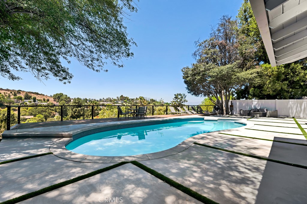 Welcome to 17072 Oak View Drive, a stunning, fully remodeled residence nestled in one of Encino’s most coveted neighborhoods. Combining timeless elegance with contemporary design, this luxurious home offers exceptional indoor-outdoor living and resort-style amenities, just moments from Ventura Boulevard’s top shopping and dining destinations. Set behind a gated entrance on a generous lot, this property offers privacy, sophistication, and striking curb appeal. Inside, the open-concept floor plan is flooded with natural light and showcases wide plank hardwood flooring, high end finishes, and a seamless flow ideal for both everyday living and entertaining. The heart of the home is a gourmet chef’s kitchen equipped with premium stainless steel appliances, quartz countertops, a waterfall island, and custom cabinetry. The spacious living and dining areas open directly to the backyard, creating a true California lifestyle experience. The luxurious primary suite is a tranquil retreat featuring a spa-style bathroom with soaking tub, dual vanities, oversized walk-in shower, and generous walk-in closet. A dedicated office and three additional bedrooms are thoughtfully designed and well-appointed for comfort and versatility. Step outside to a private backyard paradise, complete with a sparkling pool, manicured landscaping, multiple lounge and dining areas, and your very own private basketball court perfect for recreation, fitness, or friendly competition.
This home is a rare offering that blends luxury, lifestyle, and location. As the day winds down, take in the beauty of the setting sun and bask in the breathtaking, unobstructed views of the city skyline, a striking reminder that this extraordinary home is truly one of a kind.