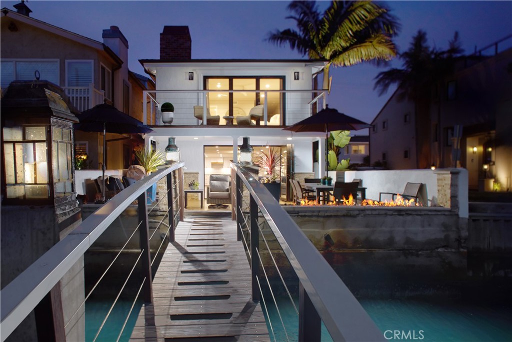 Sunlight dances across the calm waters of Newport Beach’s cherished channels, where a rare corner-lot rests at the end of a peaceful cul-de-sac in the coveted Finley Tract. Moments from the sand, Lido Marina Village, Lido House Hotel, and a collection of charming boutiques and dining spots, this two-level coastal retreat offers an effortless blend of privacy, sophistication, and ease.
Thoughtfully designed for connection, the newly renovated interior begins at a welcoming Dutch door and opens into a bright, open floor plan. An entertainer’s kitchen anchors the space with an expansive quartz-topped island and chef-worthy appointments including a custom range hood, and premium SubZero and Wolf appliances
The living space flows beside it with a sleek fireplace, and a striking modern floating staircase. Glass sliding doors invite the outdoors in, leading to a generous waterfront deck with firepit—ideal for al fresco evenings or sun-drenched afternoons beside the bay.
A private dock extends the lifestyle, accommodating space for two vessels up to 35' along with a slip suited for a Duffy or dinghy, plus easy access to launch paddle boards and other water toys from your own backyard.
Upstairs, the sun-filled primary suite offers a serene escape, featuring a cozy fireplace, spa-inspired bathroom, dual walk-in closets, and a private balcony with shimmering water views from sunrise to sunset. Two additional bedrooms—one enjoying views of the water—provide flexible space for guests or office. A full laundry room and an attached two-car garage complete the home.
Where timeless design meets the rhythm of the coast, this is your front-row seat to the best of the Newport Beach lifestyle.