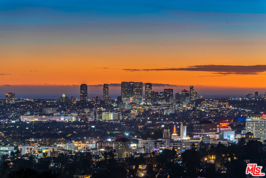 Discover an unparalleled sanctuary atop the prestigious Oaks enclave. This gated, modern masterpiece, set on a commanding 3/4-acre promontory, delivers sweeping 300-degree views from the iconic Hollywood Sign to the Pacific Ocean and the glittering downtown skyline while maintaining the utmost privacy and serenity. The home's free-flowing, open-concept design is framed by floor-to-ceiling glass, seamlessly integrating the luxurious interior with multiple Ipe wood decks for an ideal indoor-outdoor experience. The main residence offers 4 bedrooms and 5 baths, including a serene primary suite with a steam shower, walk-in closet, automated blackout shades, and a private deck. Every angle of the bright chef's kitchen, dining area, living room and media room is bathed in incredible natural light and spectacular views. A detached 1-bedroom glass pool house opens to a magnificent infinity-edge saltwater pool with swim jets and underwater speakers. The property's curated amenities include heated floors, a full Sonos system, solar power, a basketball deck, EV charger, ensuring a lifestyle of ultimate comfort and sophistication. With a 2-car garage and gated parking for 5, this luxury custom home is a true escape that will not disappoint. Notably, one of the last residences photographed by the legendary Julius Shulman, cementing its status as an icon of timeless California modernism.