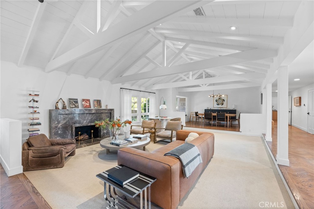 Beautifully remodeled Encino estate set on an expansive 15,000sqft flat and fully usable lot. This exceptional property features 6 bedrooms, including a detached 600 sqft ADU. Set off the street with a generous grassy front lawn, this home offers privacy, charm, and plenty of space to relax or entertain. Upon entering, you’re greeted by vaulted ceilings with exposed beams and a seamless open-concept plan. The great room features a custom Italian marble fireplace and flows into the dining area, ideal for hosting gatherings. The chef’s kitchen is adjacent to the family room complete with a sleek bar and cozy, wood-burning fireplace. The two powder bathrooms showcase stylish vanities and limewash / roman clay walls. All bedrooms are thoughtfully tucked away from the main living spaces for maximum privacy. The primary suite is a true retreat—featuring an Italian marble rain shower with bench and niche shelving, a free-standing soaking tub, double sink vanity and a custom make-up vanity. A highlight of the primary suite is the massive walk-in closet centered around a marble island and Soho Home chandelier, plus a bonus coffee station with mini fridge. The home is designed to wrap around the serene backyard with multiple access points through french doors. Step outside to enjoy the sparkling saltwater pool/spa with rock waterfall, the shaded courtyard, vegetable garden, or play on the low maintenance turf. This property offers a detached ADU structure featuring 1 bedroom, 1 bathroom, and a full kitchen and living space, perfect to utilize as a guest house, game room/pool house, or private office. Situated adjacent to Libbit park and within the Hesby Oaks school district, this is a rare offering in a sought-after location. This turnkey property combines elegance, convenience, and thoughtful design at every turn. Bonus Alert: EV charger in garage, security cameras, bonus massage room/mini gym/kids study, large laundry room with ample storage.