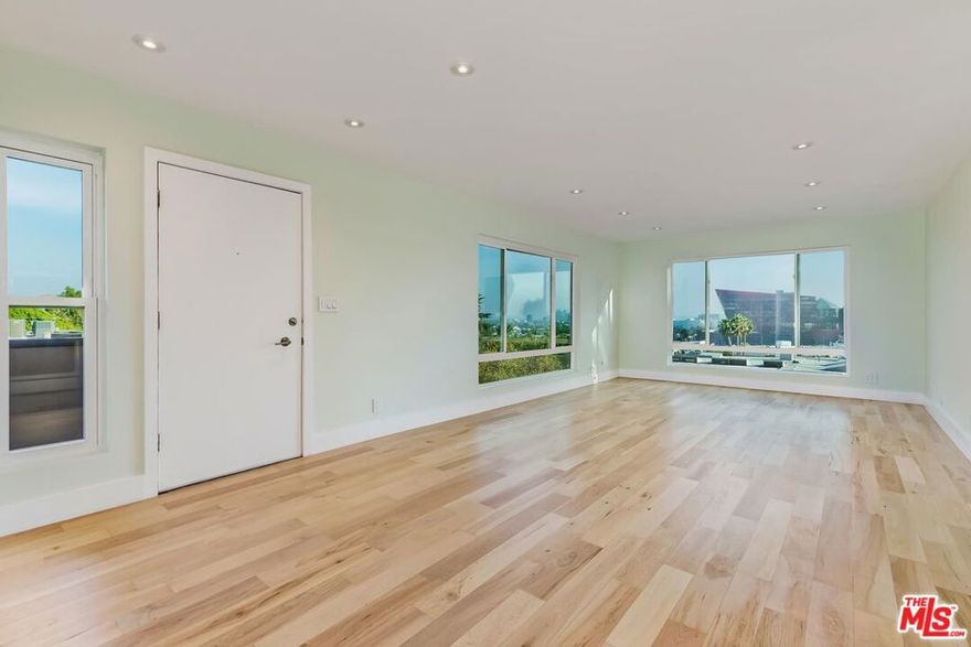 This top-level end unit showcases sweeping views of the iconic Pacific Design Center and the glittering city skyline from nearly every room. Perched on a hillside between fashionable Santa Monica Boulevard and the famed Sunset Strip, this home captures the best of vibrant city living and serene retreat. Recently updated, the unit combines modern comfort and timeless style. The light-filled living room features expansive windows that frame the skyline like a work of art, complemented by engineered maple hardwood floors that add warmth and elegance throughout. The black-tiled open concept kitchen is both stylish and functional, complete with newer stainless steel appliances. The primary suite offers a peaceful escape, illuminated by natural light. Spacious closets add generous storage while enhancing the airy feel. Both bathrooms have been thoughtfully upgraded with modern, sophisticated finishes. On the ground floor, a grand lobby opens to a lush resort-style courtyard featuring a large heated pool, spa, and shaded dog walk area, offering an ideal blend of luxury, comfort, and quintessential California lifestyle.