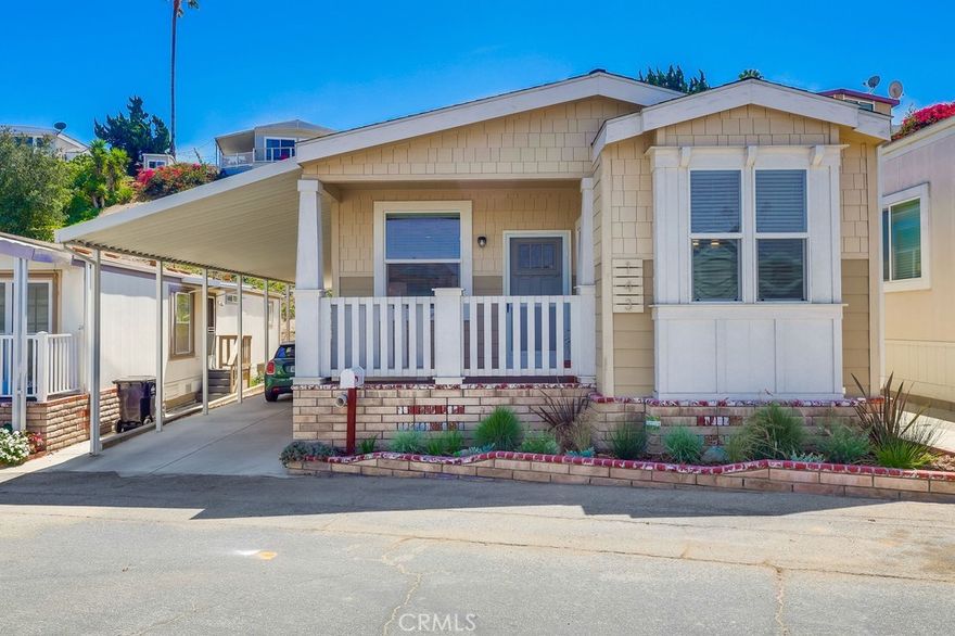 Welcome to 2550 Pacific Coast #143, a spectacular Craftsman-style 2-bedroom, 2-bathroom 1,200 square feet designer home in the Skyline Mobile Community! Charming newer 2019 build turnkey home is located on a quiet walk street. Open & airy home offers a sense of tranquility & ease featuring sunrises & sunsets, multiple outdoor seating areas, low maintenance yard, central A/C & heat, dual pane windows, 9-feet high ceilings, laminate floors, ceiling fans, custom blinds & crown molding. As you enter the home you walk into the spacious living room boasting natural light, high ceilings, recessed lights, laminate floors, ceiling fan & custom blinds. Kitchen opens to the living room & dining area. Kitchen is well equipped w/island, storage & shelving, 3-seat breakfast bar, recessed lights, farmhouse sink, stainless steel appliances including gas stove, oven, fridge (w/built-in ice maker/water), microwave, dishwasher, tile backsplash, butternut shaker hardwood cabinets, plentiful countertop space, custom blinds & laminate floors. Cozy dining area stuns w/exquisite chandelier, laminate floors & 3 windows pouring in natural light. Primary bedroom features massive closet, new carpet, ceiling fan, natural light, high ceilings, recessed lights & bathroom ensuite. Primary bathroom showcases soaking tub, walk-in shower, laminate tile floors, dual sink vanity, Quartz countertops, butternut hardwood cabinets & linen closet. Guest bedroom is the perfect size to convert to an office & home gym! Guest bedroom offers plentiful closet space, ceiling fan, laminate floors, custom blinds & exquisite wallpaper. Guest bathroom has a tub/shower combo, single sink vanity, butternut hardwood cabinets, Quartz countertops, recessed lights, medicine cabinet & laminate tile floors. Laundry room comes fully equipped w/washer & dryer, cabinets for storage & pet door. Exterior home offers quaint Trex deck w/brick skirting & garden planter, low maintenance landscaping & spacious back patio/terrace. Carport fits 3 cars on newer concrete driveway. Property taxes are ~$1,400/yr. Home located in excellent school district & near Whole Foods, Trader Joe’s, Starbucks, movie theater, restaurants, hospitals, freeway & beaches. Community boasts amenities including security guard gate, community rec center, pool, hot tub, BBQ, billiards, shuffleboard, kitchen, darts, putting green & on-site manager. Monthly events include movies, water aerobics, yoga, poker, line dance, karaoke, guitar, tai chi & Bingo.
