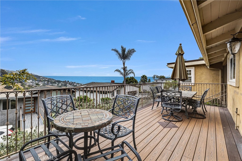 Set above the Village in Temple Hills, this ocean-view residence blends dramatic indoor/outdoor living with the ease of single-level spaces. A vaulted, open-beam great room anchored by a carved fireplace opens to a front deck boasting stunning ocean and hill views. The elegant kitchen adjoins the dining area and living room for effortless entertaining. Three bedrooms and two baths include a view primary suite with sitting area/retreat and a primary bathroom with featuring dual vanities, walk-in shower and soaking tub overlooking the hills. Outdoors, a private paver courtyard hosts a built-in BBQ and island with sink; brick pathways climb the terraced .24-acre lot to a hilltop gazebo—multiple places to dine, lounge and take in the scenery. Additional highlights: owned solar, wood floors, washer/dryer and refrigerator included, attached 2-car garage with EV outlet, outdoor storage shed, and no HOA. Enjoy quick access to Laguna’s beaches, galleries, dining and hiking.