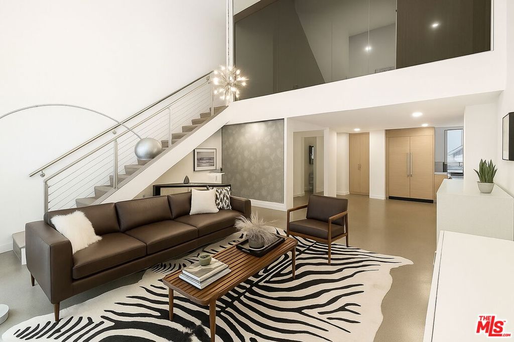 Available November 1, 2025. Striking tri-level loft by Pugh + Scarpa showcasing soaring 20-ft ceilings, polished terrazzo, and wide-plank oak floors. Sun-drenched interiors open seamlessly to a private patio, while the chef's kitchen features Caesarstone counters and custom cabinetry. A rooftop deck with outdoor kitchen, dining, and lounge captures sweeping city and Hollywood Hills views. Modern comforts include smart home controls, in-unit laundry, and secure parking for two. Ideally located near the Beverly Center and just steps from West Hollywood in a prime Mid-City setting.