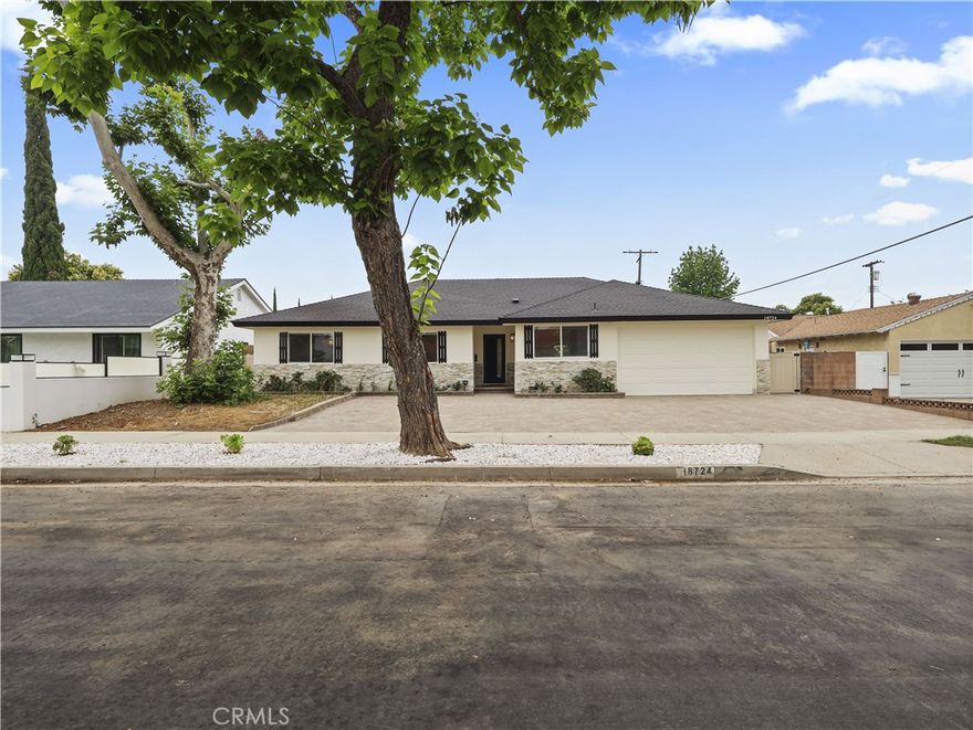 Be the first to enjoy an unmatched level of design, luxury upgrades, space and privacy, showcasing quality and style that exceed modern standards. This fully remodeled 4-bed, 2.5-bath single-story home, reimagined with no expense spared, offers 1,711 sq ft of living space on an oversized 7,508 sq ft lot. Located on a quiet, tree-lined street in central Northridge near the Northridge Fashion Center and CSUN, this home features impressive curb appeal with fresh paint, stone accents, black trim and a sleek modern front door. The paver driveway offers parking for 3–4 cars, plus a 2-car garage. Inside, a formal entry leads to a truly open layout that combines the living room and the dining area, both overlooking the covered patio and an unbelievably large backyard. The floorplan includes a dream kitchen with direct garage access, guest powder room, hallway bath, and a spacious primary suite with a beautifully upgraded ensuite. This kitchen is a showstopper, featuring two-tone cabinetry with crisp white uppers and deep navy lowers, accented by gold hardware. Quartz countertops and a full-height subway tile backsplash provide a clean, refined finish. A spacious window over the sink, equipped with automated roller shade, fills the space with natural light, while stainless steel LG appliances deliver functionality. The bright primary bedroom offers dual closets and a spa-like ensuite with a floating wood vanity, brushed gold fixtures, frameless glass shower, mosaic tile floor and dual showerheads. Three additional bedrooms are bright and updated with stylish finishes. The hallway bath includes brushed gold accents and a glass-enclosed walk-in shower with elegant tilework and dual showerheads. A chic half bath adds convenience with a navy vanity and gold fixtures. The finished 2-car garage offers direct access, a separated laundry area with washer and dryer and an EV charger. Upgrades include wide-plank laminate flooring, dual-pane windows with roller shades, recessed lighting, modern interior doors, soft-close closet doors, stylish door handles and central air and heat. The private backyard is a true retreat, fully enclosed with block walls and designed with newly installed pavers, lush artificial turf and mature trees. The expansive covered patio provides the perfect space for entertaining or simply relaxing outdoors, where every inch has been meticulously finished with easy maintenance in mind. Now accepting applications. Schedule your private showing today!
