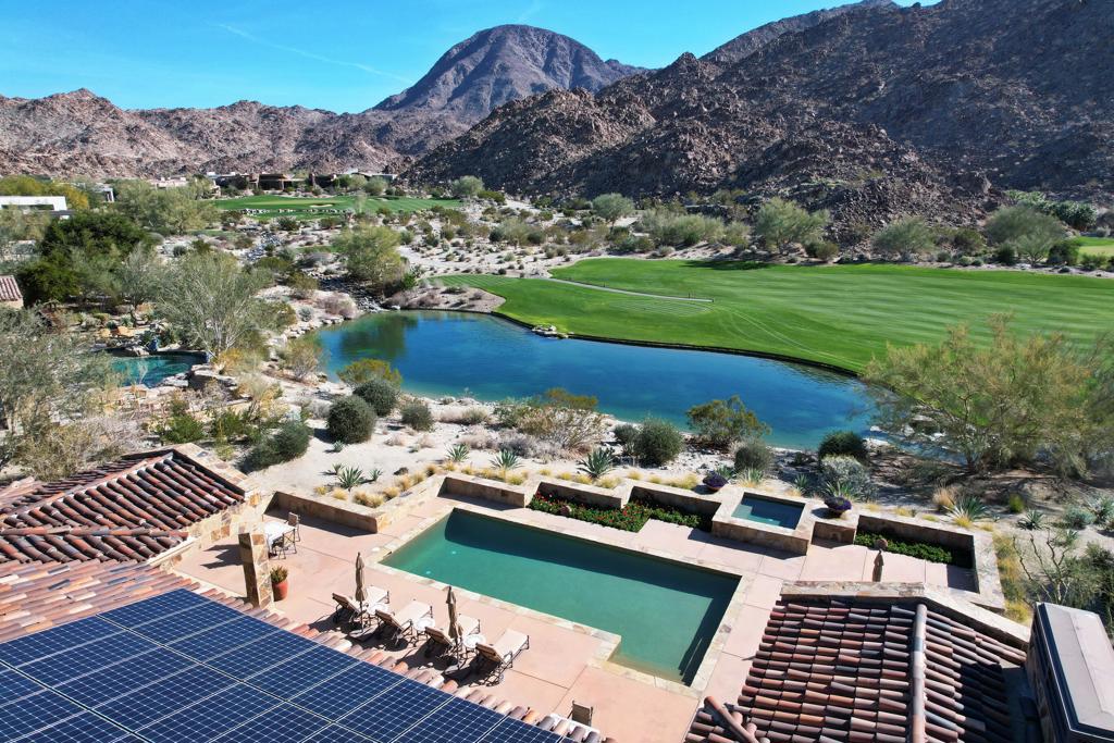 This stunning custom home is located within the prestigious Reserve Club nestled along the 18th fairway with spectacular water and southern mountain views. The spacious courtyard entry opens to a generous great room including wall to wall sliding glass doors, soaring beamed ceilings, dining area, temperature controlled wine room, wet bar and gracious gathering spaces around the beautiful fireplace. Thoughtful and unique architectural details of stone and wood bring warmth and comfort to every room. An amazing chef's kitchen is expansive with a large center prep island, breakfast bar and brilliant windows bring in the outdoor scenery. The lovely master retreat, separate office, 2 guest bedrooms and an additional private guest quarters with sitting room complete this exceptional home. To optimize energy efficiency this residence has extensive solar panels and an updated A/C system has been installed in the last 3 years. The spectacularly designed back patio overlooking the lake and golf course is truly a desert oasis with an easy transition from indoor to multiple outdoor spaces. The pool, spa and covered outdoor kitchen is the perfect place to entertain family and friends while soaking in sunrises, sunsets and unobstructed and endless mountain views.