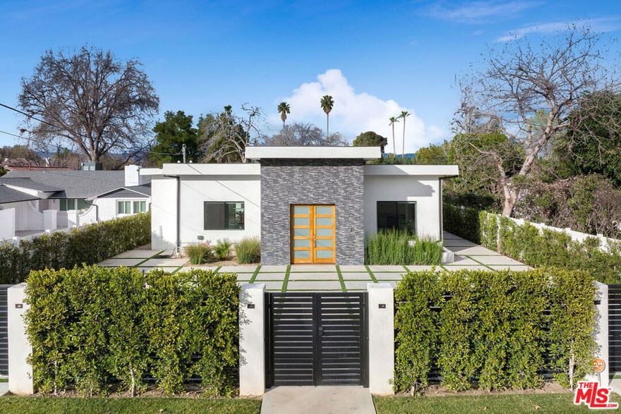 Welcome to Woodland Hills, where luxury meets creativity in this exquisite home featuring a state-of-the-art detached professional recording studio. This fully equipped facility is a dream for music enthusiasts and includes a complete production suite along with a soundproof recording booth. Additionally, an auxiliary studio located within the main house offers flexible space for various creative projects, from streaming to podcasting and production.The main residence showcases a sleek, modern design complemented by warm finishes, striking the perfect balance between style and comfort. With four spacious bedrooms and five and a half bathrooms spread across 5,000 square feet, this home boasts an expansive open layout that flows effortlessly throughout. The kitchen, living, and dining areas harmoniously connect, surrounding a beautiful pool and spa that serve as the centerpiece of this stunning property. The primary suite is a true sanctuary, featuring an oversized walk-in closet and a luxurious bathroom designed for relaxation and rejuvenation. This Woodland Hills gem is not just a home; it is an entertainer's paradise and a hub for creativity, perfect for hosting gatherings or cultivating artistic endeavors.