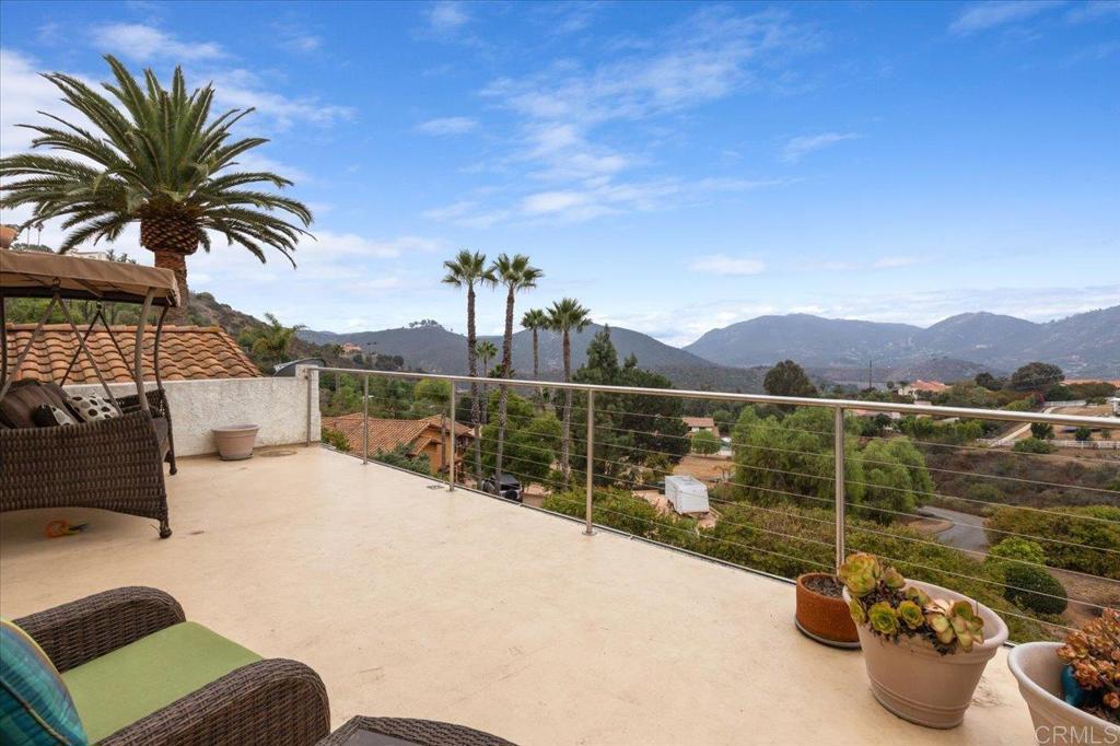 Introducing a stunning residence nestled in the vibrant city of Escondido, providing the perfect blend of comfort, style, and convenience. This exceptional property boasts five bedrooms (one is converted to an office), and includes a spacious primary bedroom with fireplace and a large, remodeled spa like bathroom that has an additional connected room to be used as an office, extra walk in closet, or a gym. The large deck off of the primary is sure to be a favorite place to watch the sunsets. Encompassing an impressive interior square footage of 3,764 sqft, the house offers ample space for both living and entertaining, all with the cost effectiveness that solar provides. A unique feature of this home are the breathtaking views of the hills and mountains of Lake Hodges from most rooms, specifically the office, the sun room, and the primary suite. Enjoy your morning coffee from the sun room or your office while looking out onto the natural beauty that is Lake Hodges. Privacy is one of this homes incredible features as the home is nestled down on a private road and two of the bedrooms are able to be partitioned off as private living space with their own bathroom for guests or additional family. The backyard and expansive lot is complete with a pool, spa, and decking for dining and promises endless opportunities for outdoor activities allowing a personal oasis for relaxation or lively gatherings. The location is exemplary, sitting comfortably close to the serene Lake Hodges, essential freeways, and various shopping hubs, ensuring all your needs are just a stone's throw away. For those who appreciate nature's touch, the proximity to Felicita Park provides a perfect backdrop for morning jogs or leisurely evening strolls. Whether hosting guests or enjoying a quiet family day, this home delivers an environment that's both welcoming and luxurious.