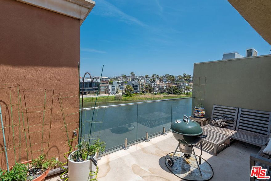 A rare chance to live just steps from the sand! This beautiful penthouse offers 2-bedrooms, 2-bathrooms, 2 parking spaces and stunning views of the Del Rey Lagoon and Marina del Rey Main Channel, with direct access to your own private rooftop deck, perfect for soaking up the sun or enjoying peaceful evenings. The townhome-style layout features warm hardwood floors, soaring ceilings, and large windows that fill the space with natural light. Recessed lighting and thoughtful design touches add to the home's welcoming feel. The chef's kitchen is both stylish and functional, with a breakfast bar, generous cabinetry, and a dining area that's ideal for hosting. Downstairs, the serene primary suite overlooks the lagoon and includes a luxurious en-suite bathroom with a deep soaking tub and heated marble floors making it your own personal retreat. An additional spacious bedroom and full bathroom complete downstairs layout. You'll also enjoy the convenience of in-unit laundry, a private storage area, and a shared bike room. HOA includes water, hot water, gas, trash, cable and Earth Quake insurance! This is coastal living at its best!