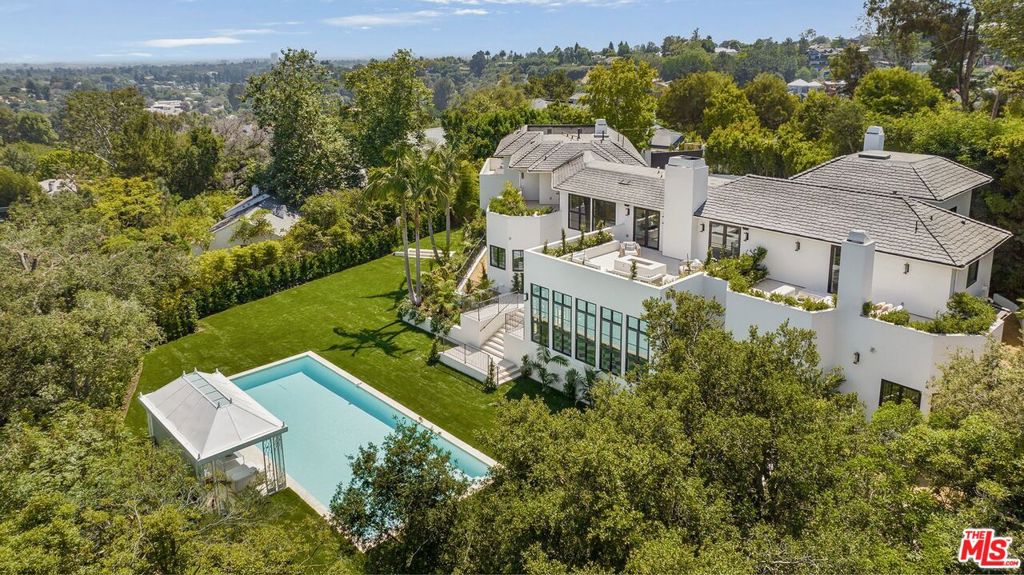 Hidden on nearly an acre, this ultra-private Lower Mandeville Canyon estate, located at the end of a cul-de-sac, offers a rare retreat of scale, timeless design, and exceptional value, surrounded by homes valued at up to forty million dollars. Located at the end of a small, quiet cul-de-sac just two streets up from Sunset Boulevard, it provides the ultimate in privacy and security. This custom 6-bedroom, 9-bathroom residence unfolds with high ceilings, city vista views, and a transitional organic modern design that nods to the elegance of Paul Revere Williams. Interior highlights include wide-plank white oak floors, a dual-island chef's kitchen with European oak cabinetry and marble countertops, and thoughtfully designed living spaces that offer effortless indoor-outdoor flow to the expansive, manicured grounds. Two primary suites, each situated on its own level, provide the ultimate in privacy and comfort, featuring luxurious spa-like bathrooms, floating vanities, soaking tubs, and designer dressing rooms. French doors throughout the home open to limestone terraces, a sprawling flat lawn, a saltwater pool, and a Hollywood Regency-style cabana designed for the pinnacle of California living and entertaining. Additional highlights include a 13-car motor court, a rose garden, a private courtyard, and thoughtfully layered landscaping that creates the feel of a true private compound. The combination of architectural integrity, estate-scale land, and an exceptional location, close to the finest dining, shopping, schools, and more, offers unmatched value at this price point. This is a true legacy home with enduring appeal in one of Los Angeles' most sought-after neighborhoods.