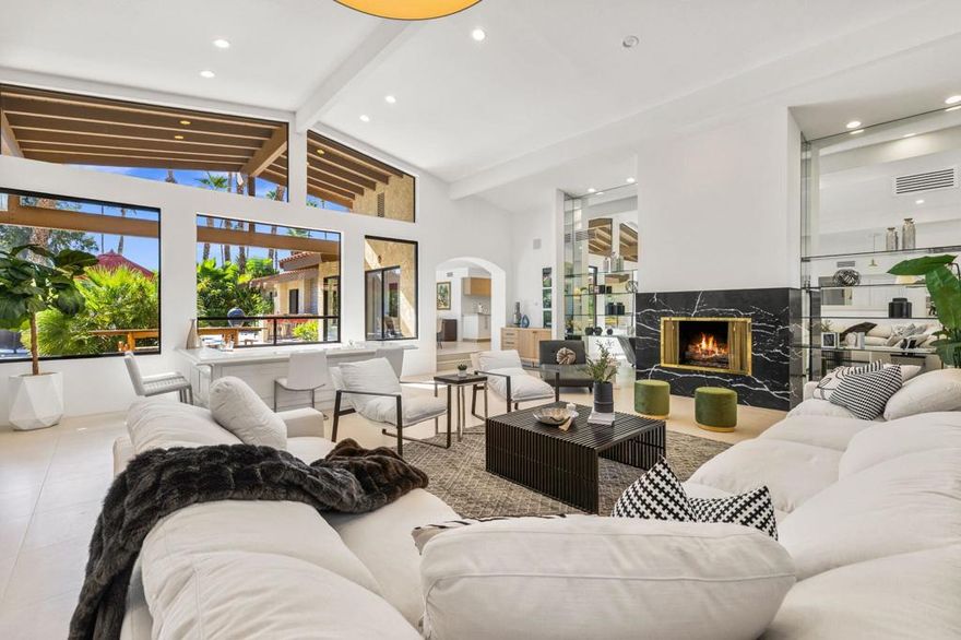 Situated in the exclusive Ironwood Heights neighborhood, this sophisticated home offers a seamless blend of luxury, sustainability, and comfort, all set against a backdrop of breathtaking mountain views and just minutes from upscale shopping and fine dining. Each bedroom features its own en-suite bathroom for maximum privacy, while the home's custom screening room/library is designed for elevated entertaining with a 100-inch retractable screen, 4K projector, onyx fireplace, and a wine bar with a glowing backlit onyx countertop. The bathrooms showcase Heath ceramic tile, custom cabinetry, and high-end fixtures by Zucchetti, Grohe, and Hansgrohe, while the gourmet kitchen is equipped with premium appliances from Smeg, Fisher & Paykel, and Bosch. Outside, enjoy thoughtfully landscaped grounds with native plants, quartzite flagstone, stone walkways, a built-in outdoor kitchen, and a natural gas firepit, all framed by new designer gates. With SunRun solar panels and three efficient heat pumps providing zoned climate control, this home perfectly merges eco-conscious living with timeless elegance in one of the desert's most sought-after communities.