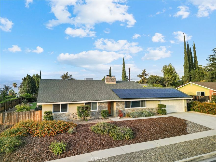 Charming Single-Story Home on a Spacious Lot in South Redlands! Welcome to this inviting 4-bedroom, 2-bathroom home offering 2,122 sq. ft. of comfortable living space on a 13,888 sq. ft. flat lot. Situated in a quiet and desirable South Redlands neighborhood, this single-story home features both a living and dining area as well as a separate family room, each with its own cozy fireplace—perfect for gatherings and relaxing evenings. The interior has been recently painted, and the layout offers great potential for customization. Enjoy the large grassy backyard, ideal for outdoor activities or future enhancements. Additional highlights include owned solar panels and battery backup and an attached 2-car garage.